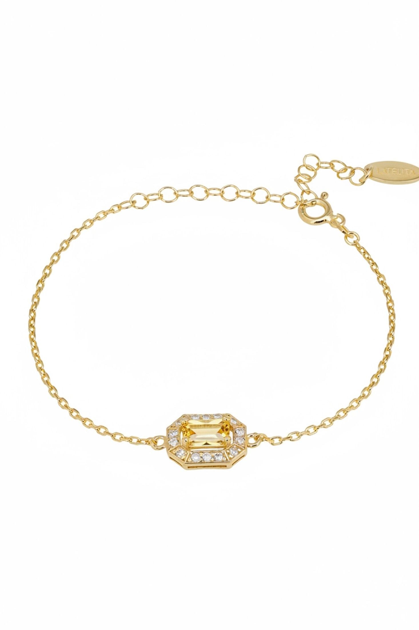 Gold bracelet with a green gemstone on a white background