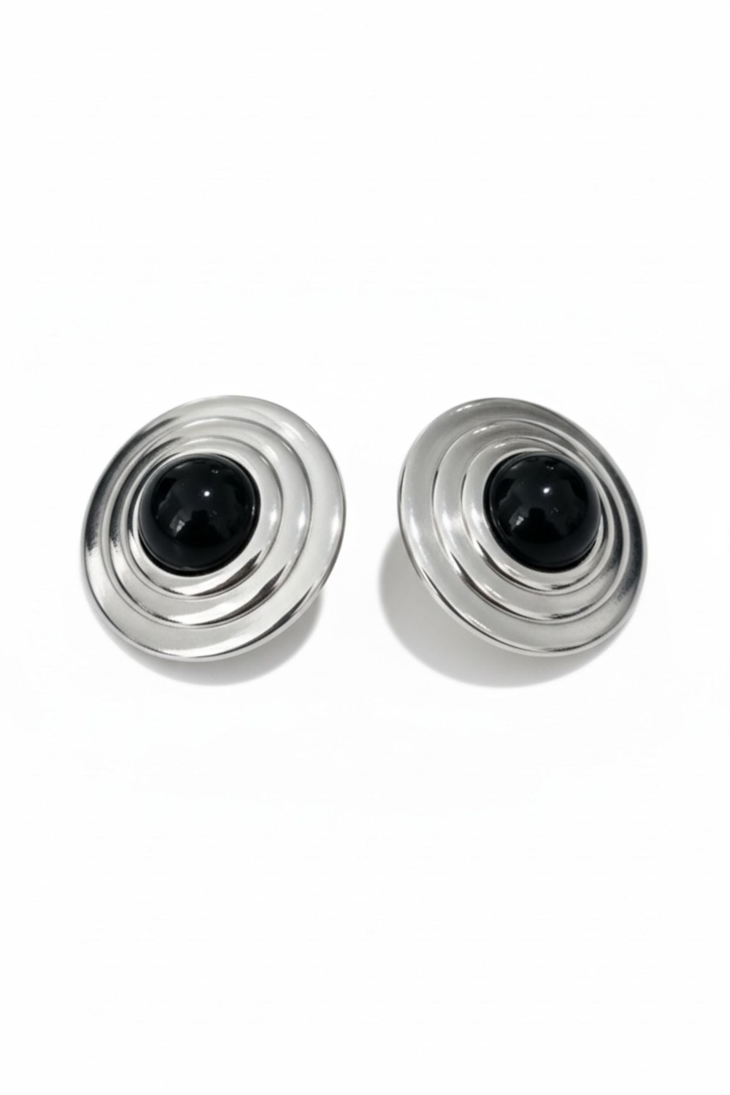 Two silver and black cylindrical earrings on a white background