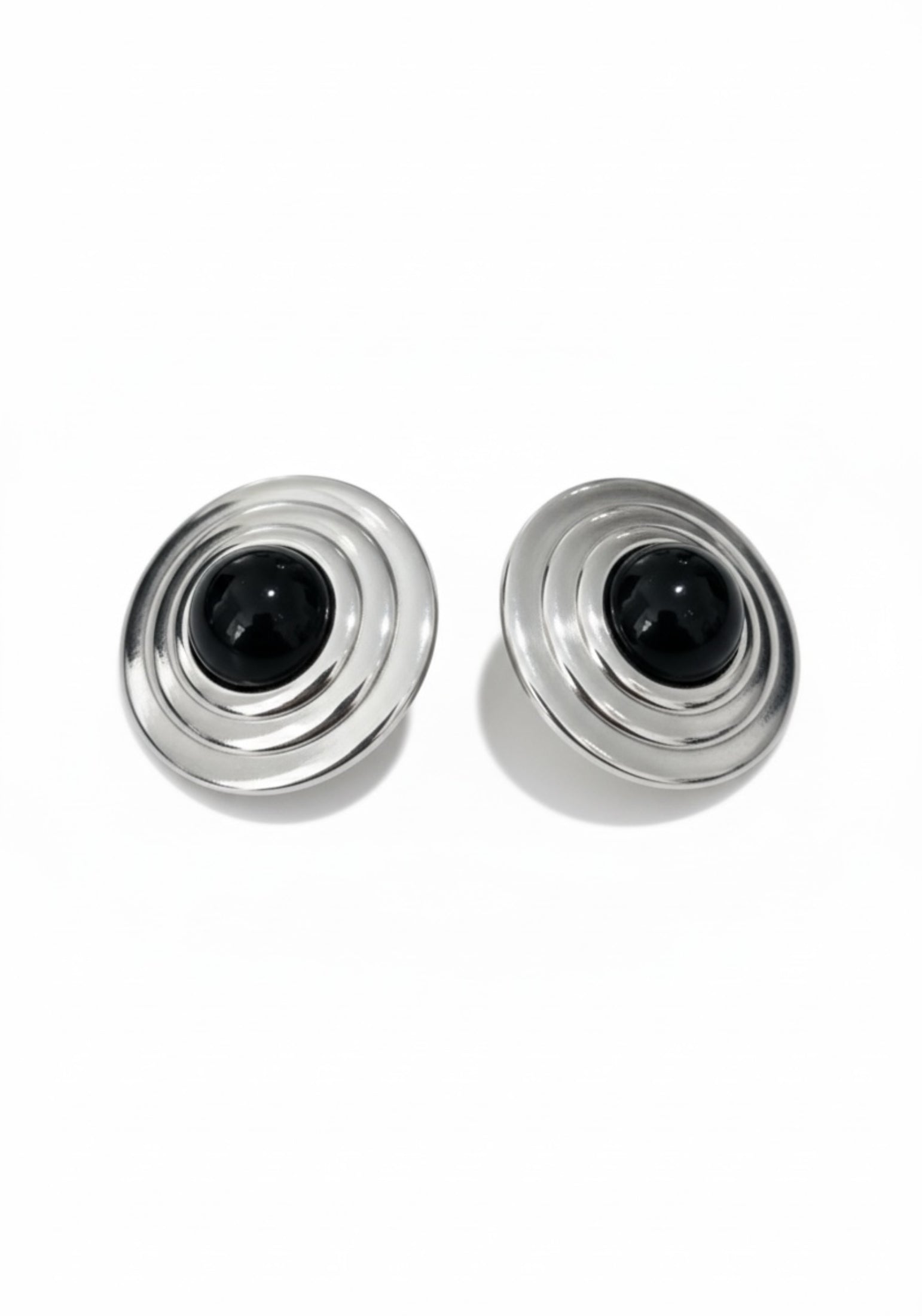 Two silver and black cylindrical earrings on a white background