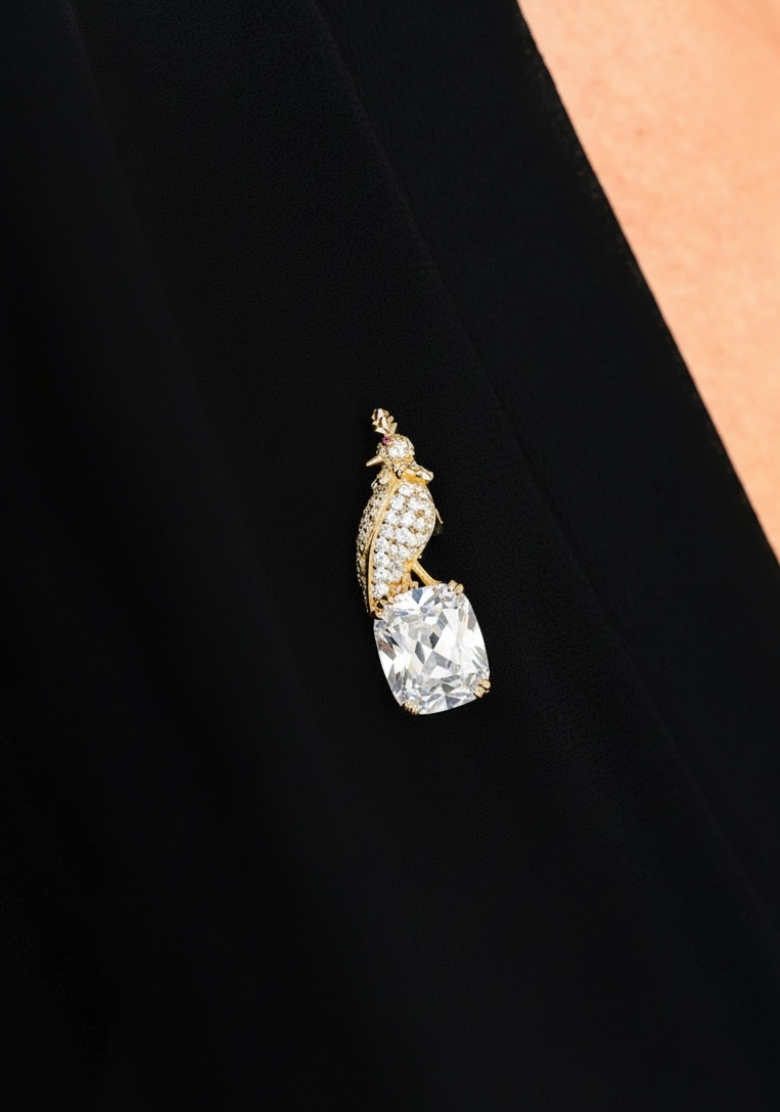 Gold and diamond brooch on a black top