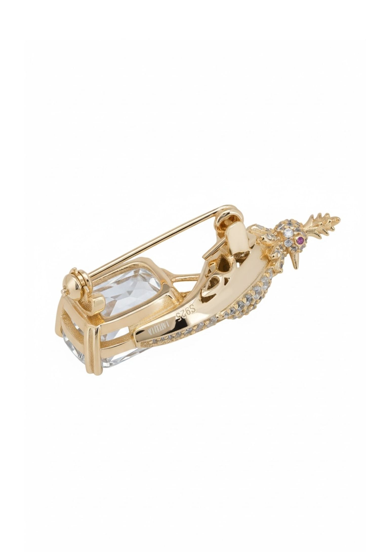 Gold brooch with a decorative bird on a white background