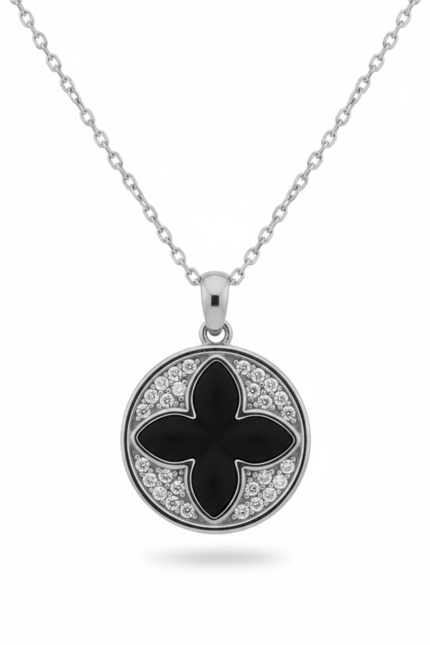 Necklace with a black clover pendant and clear stones on a white background