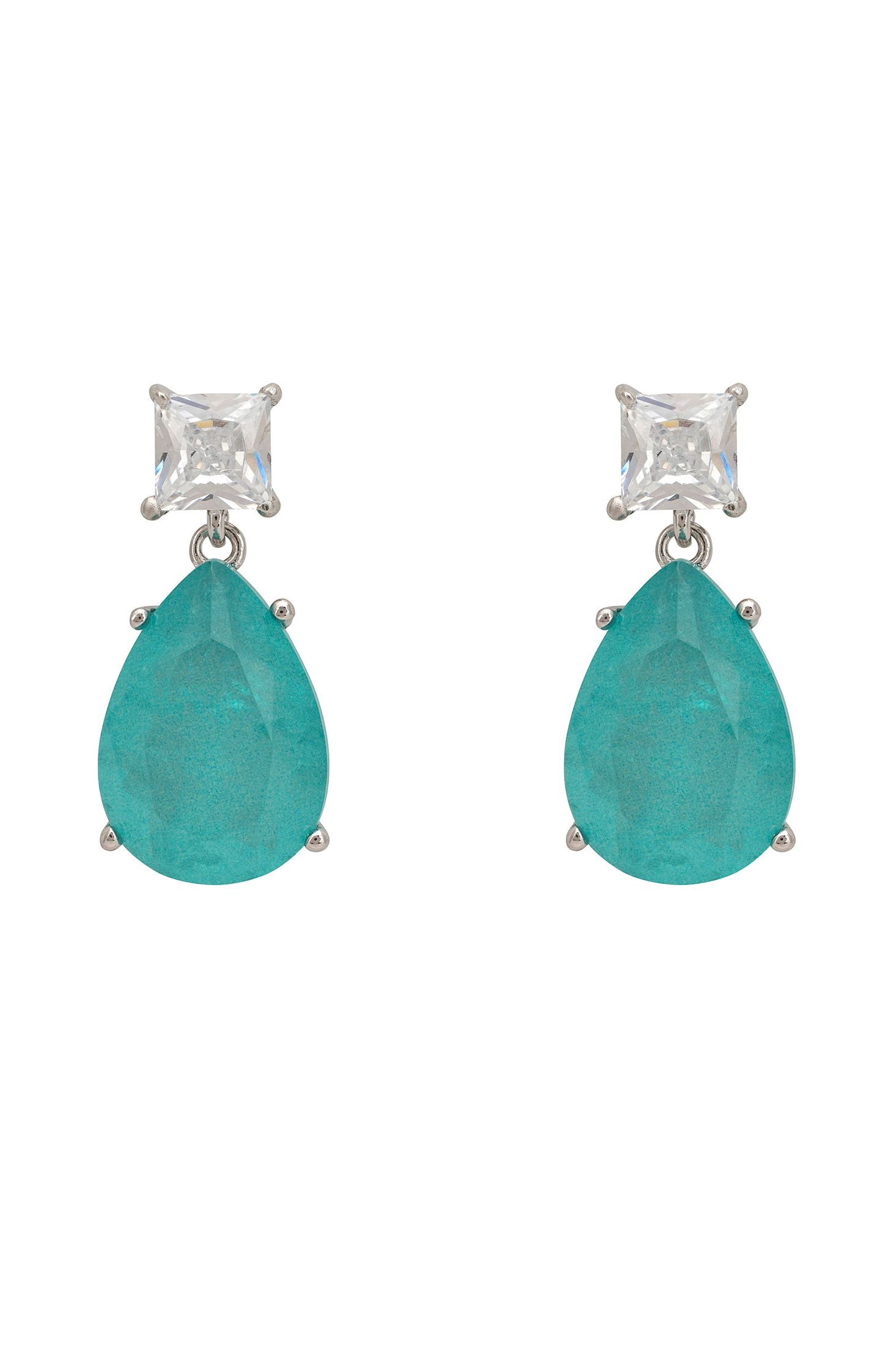 Pair of earrings with blue teardrop stones and clear gemstones on a white background