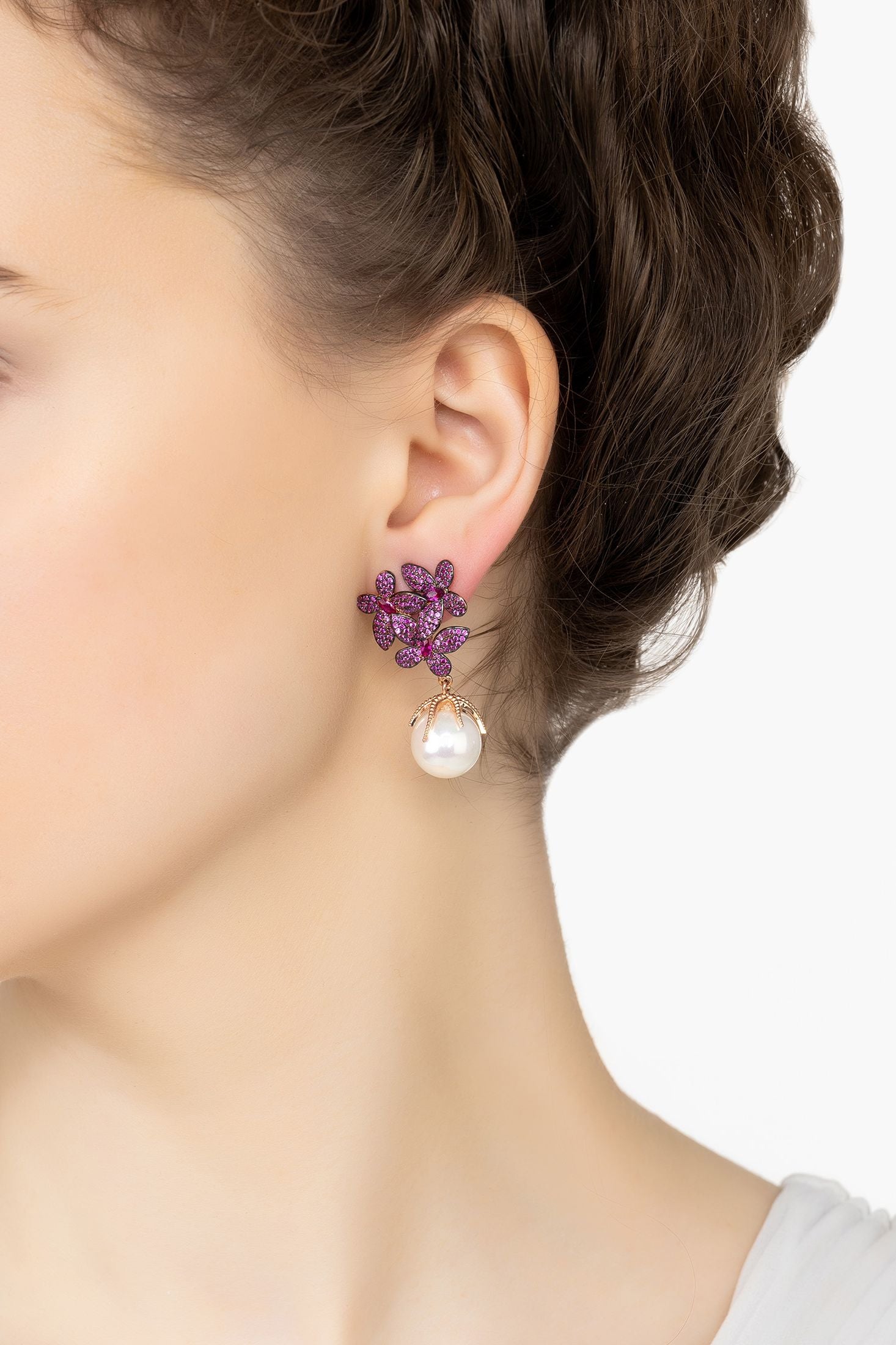 Angled view of Flowers Pearl Earrings Ruby Pink Rose Gold, showing flower design, pearl and ruby detailing, rose gold finish and the jewellery profile.