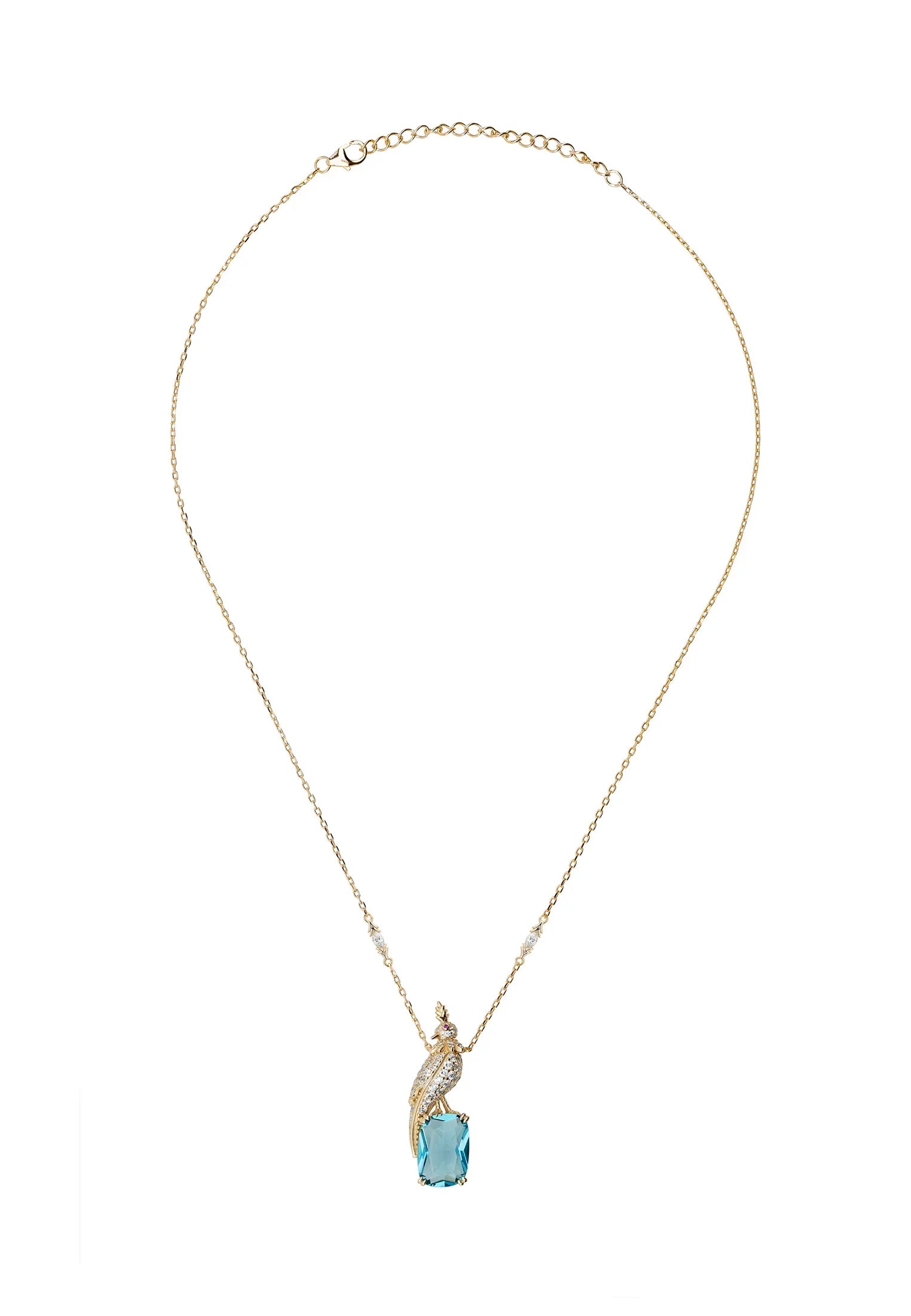 Diamond and gold bird perched on a blue gemstone, a gold charm necklace.