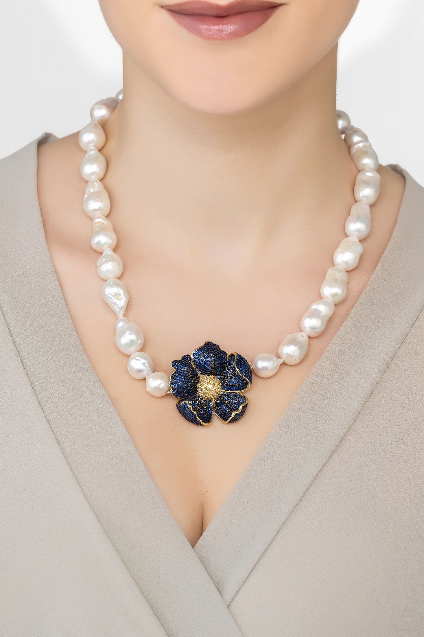 Angled view of Poppy Flower Baroque Pearl Necklace Sapphire Blue Gold, showing flower design, baroque pearl and pearl detailing, gold finish and the jewellery profile.