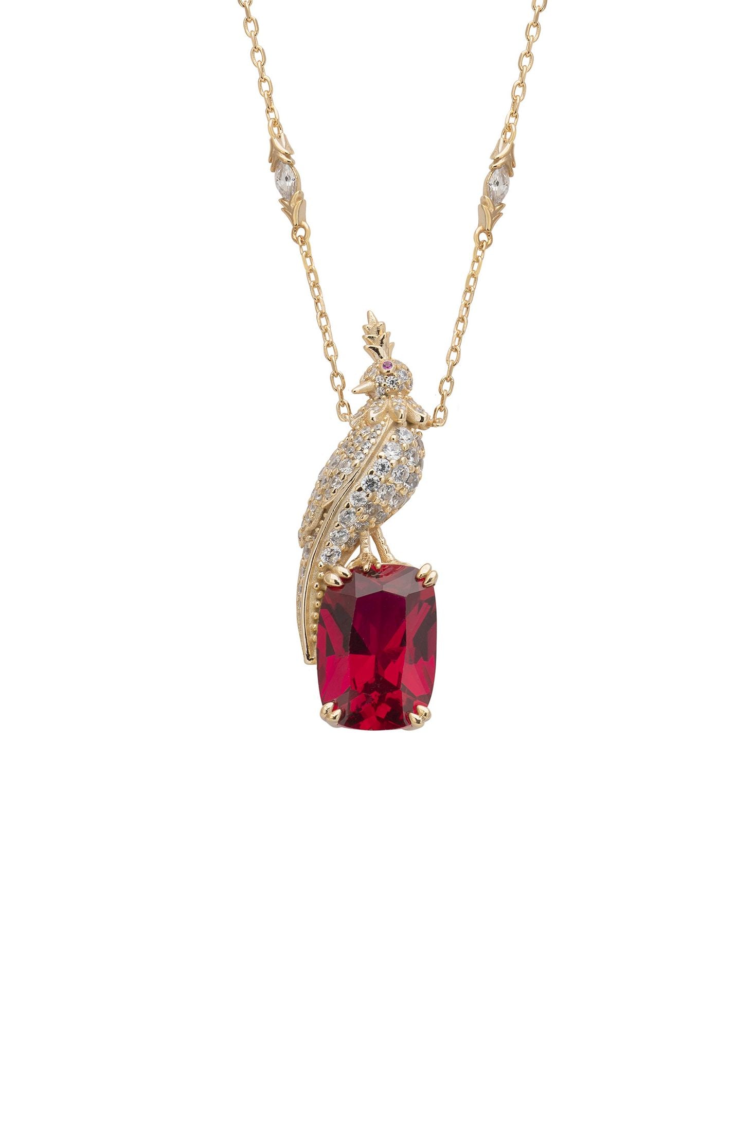 Gold necklace with a red gemstone pendant on a white background