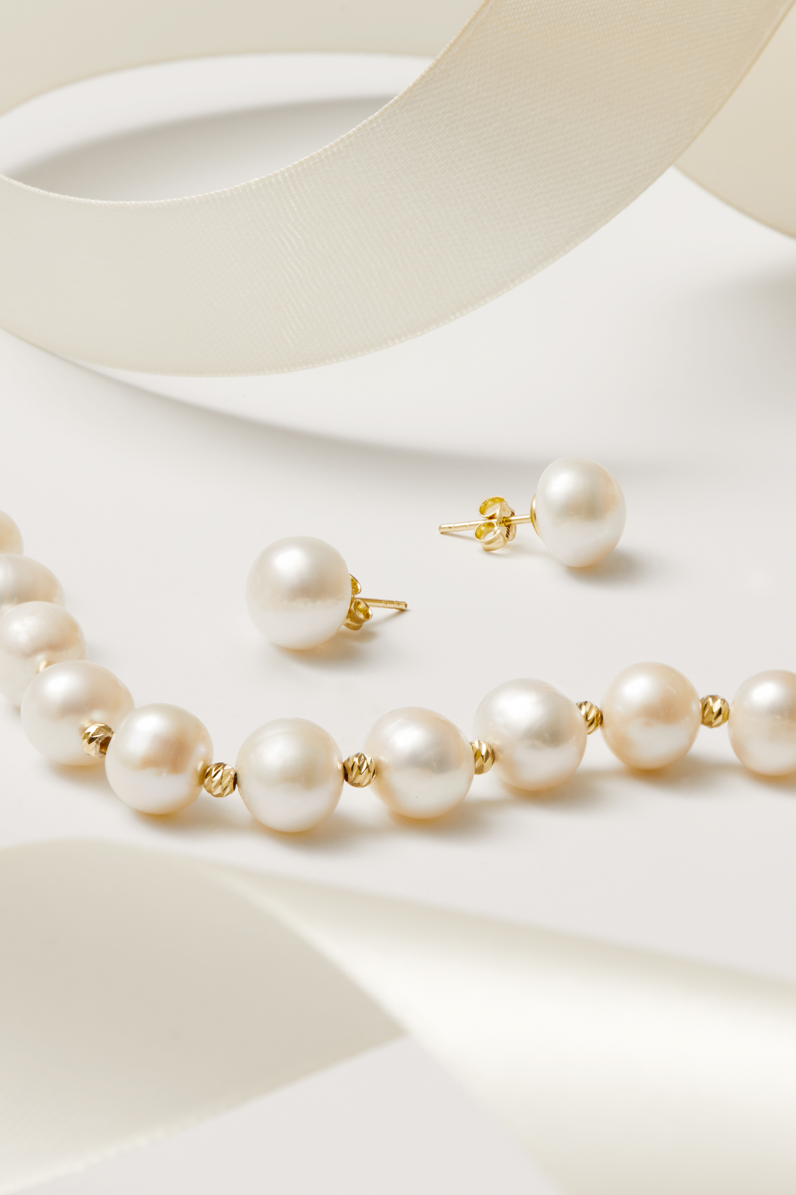 Close-up of Solid 14K Gold 11mm Classic Natural Pearl Stud Earrings, highlighting pearl detailing, gold finish.