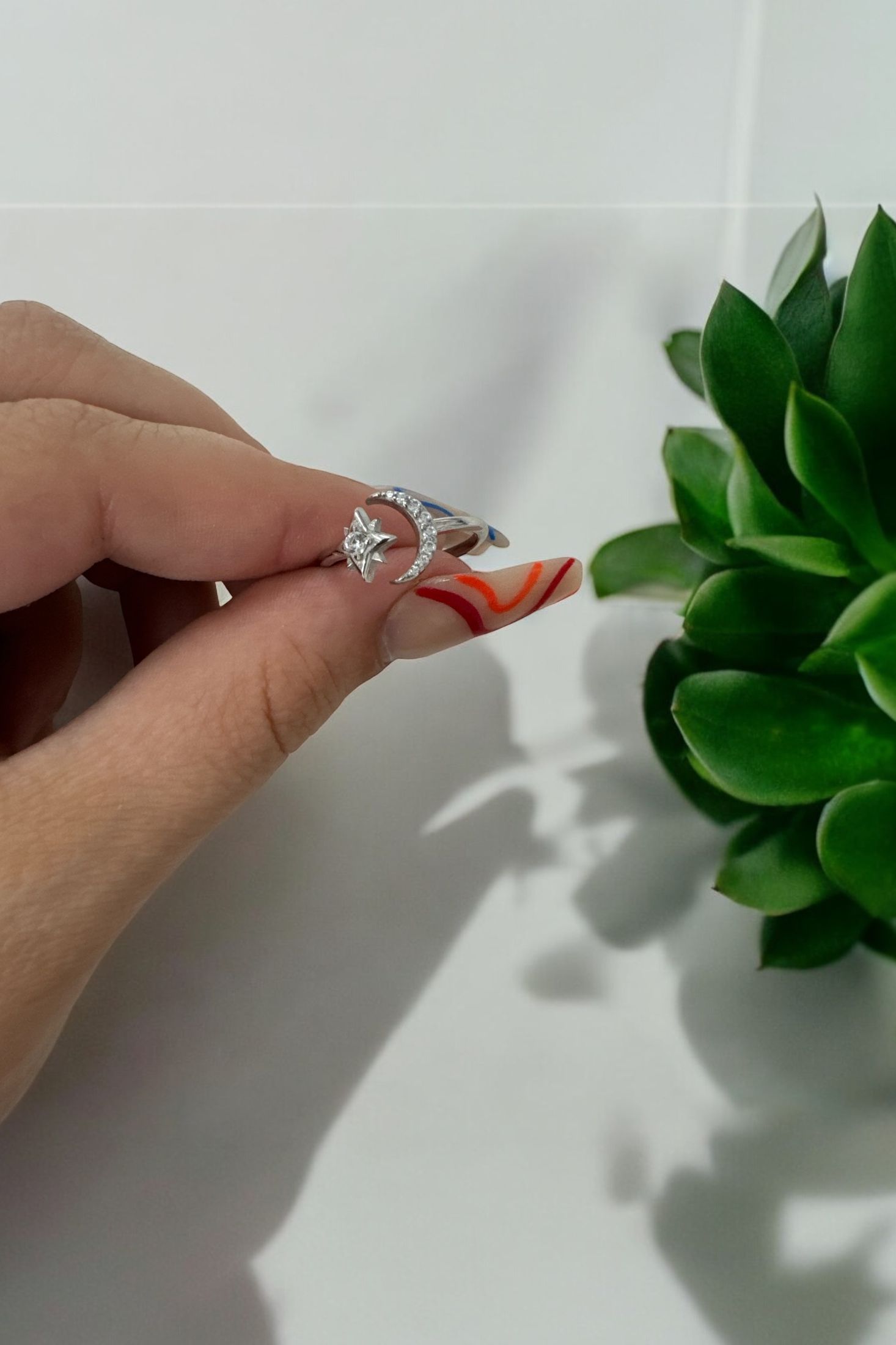 The ring held up by a hand model.