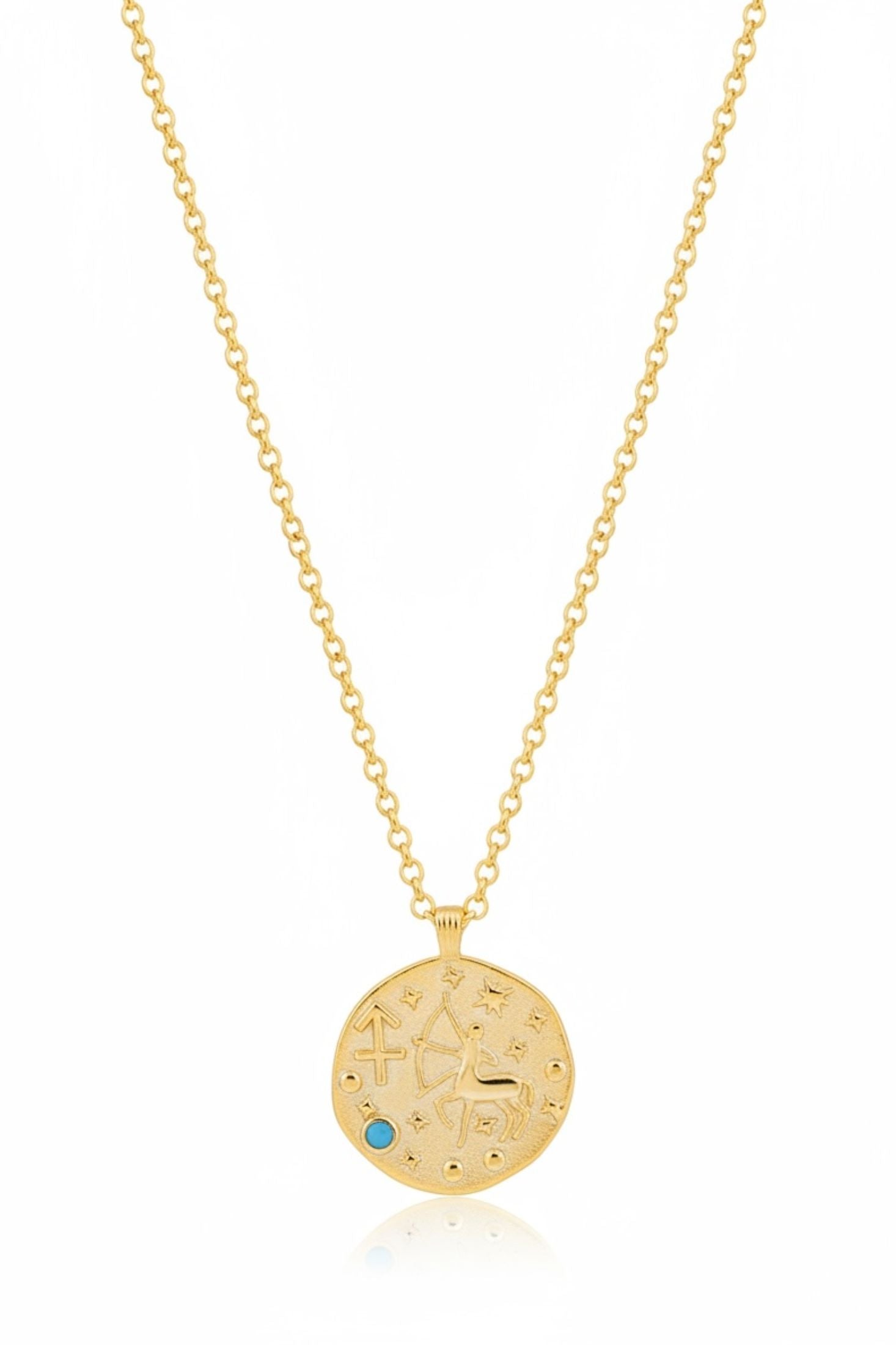 Gold necklace with a circular pendant featuring engraved text and a blue gemstone on a white background.