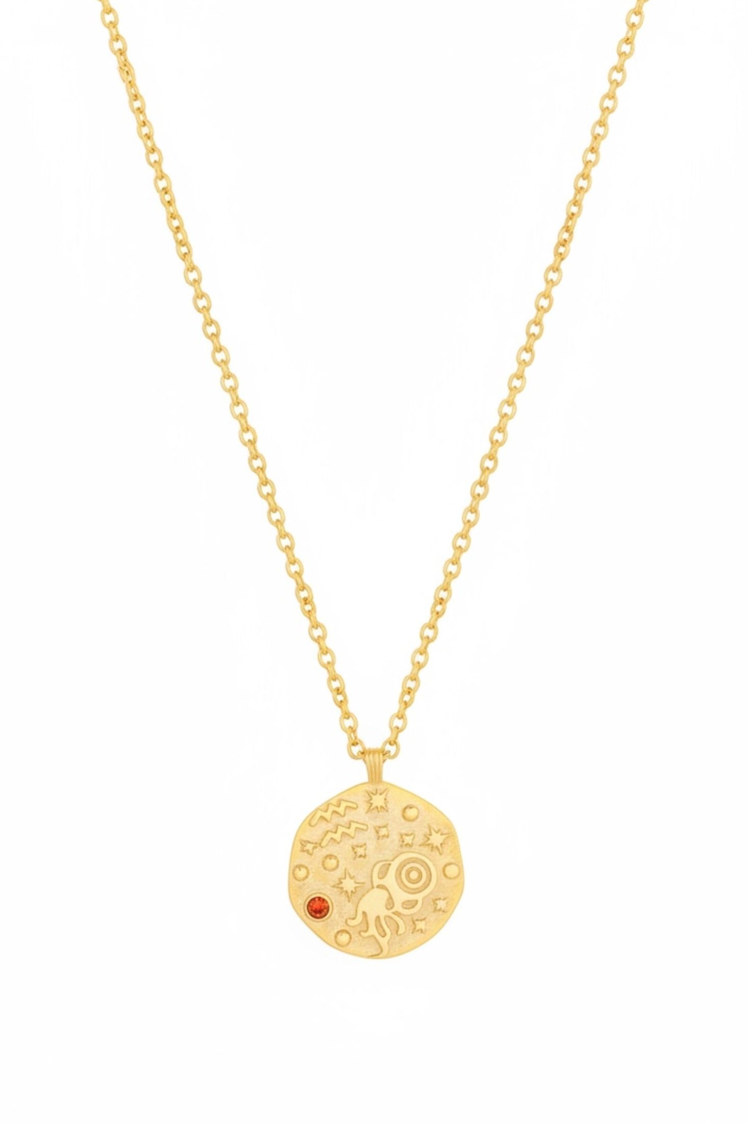Gold necklace with a round pendant featuring a red gemstone on a white background