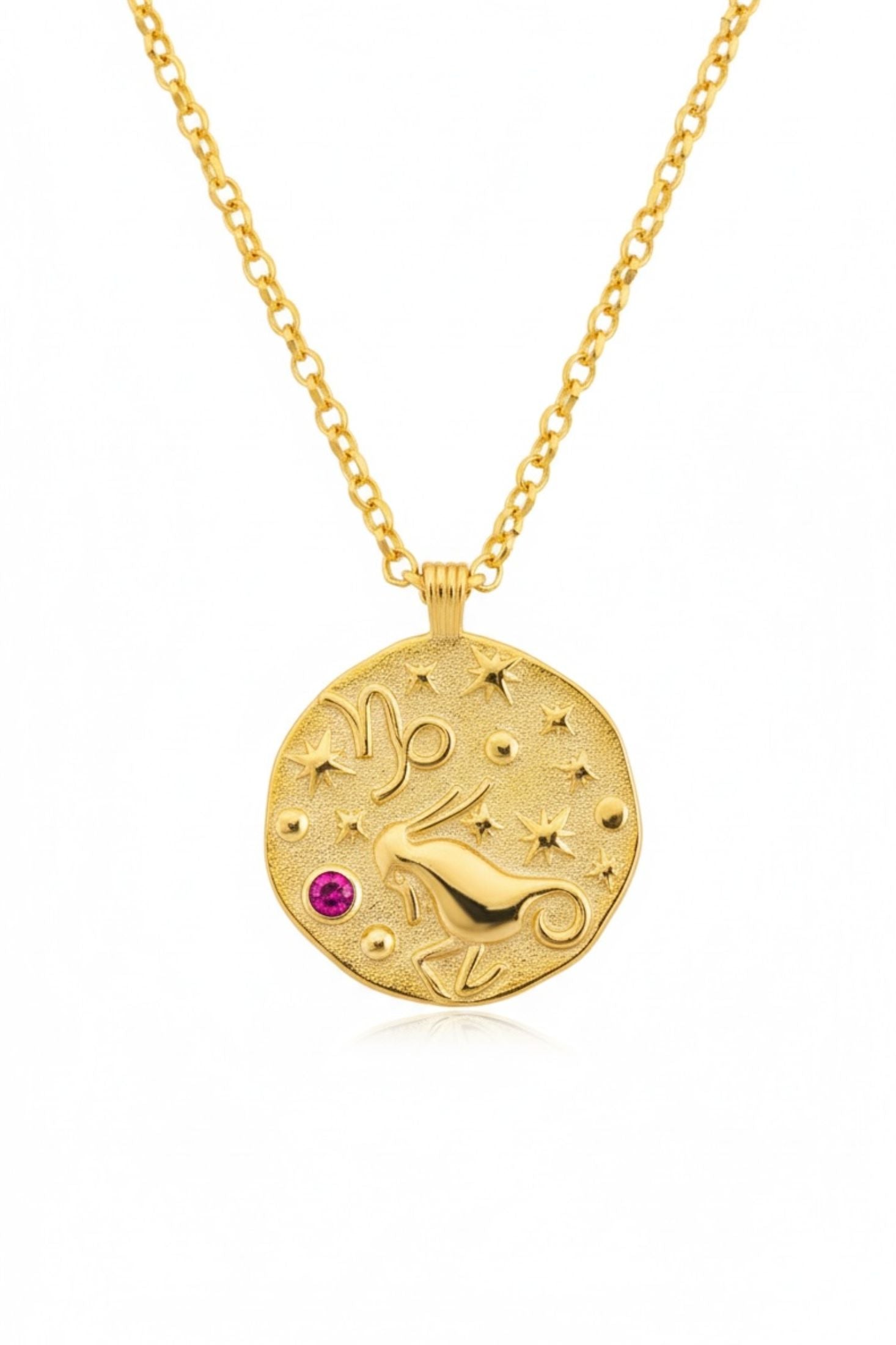 Gold necklace with a circular pendant featuring a design and a red gemstone on a white background