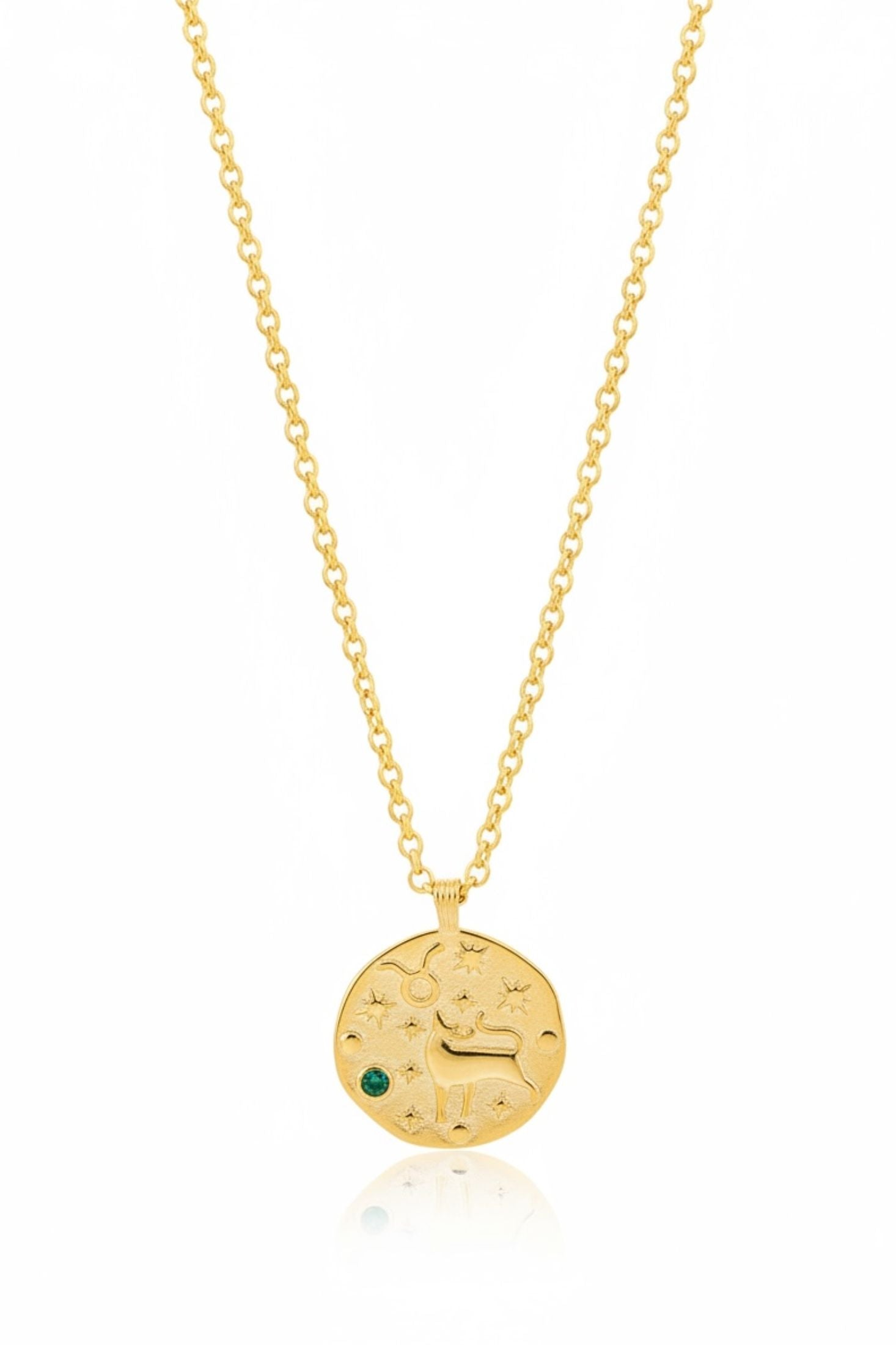 Gold necklace with a round pendant featuring an engraved design and a green gemstone on a white background.