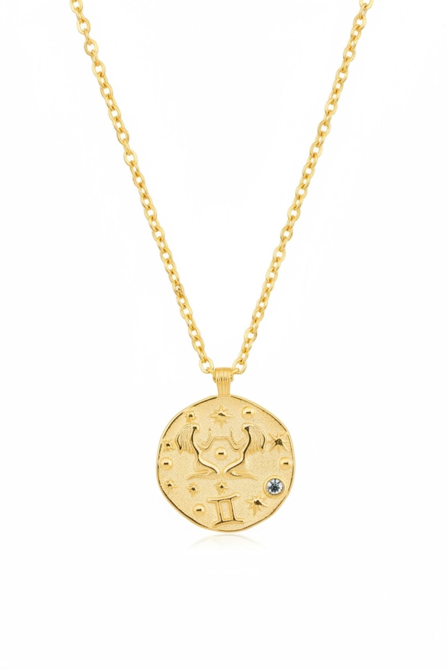 Gold necklace with a round pendant on a white background