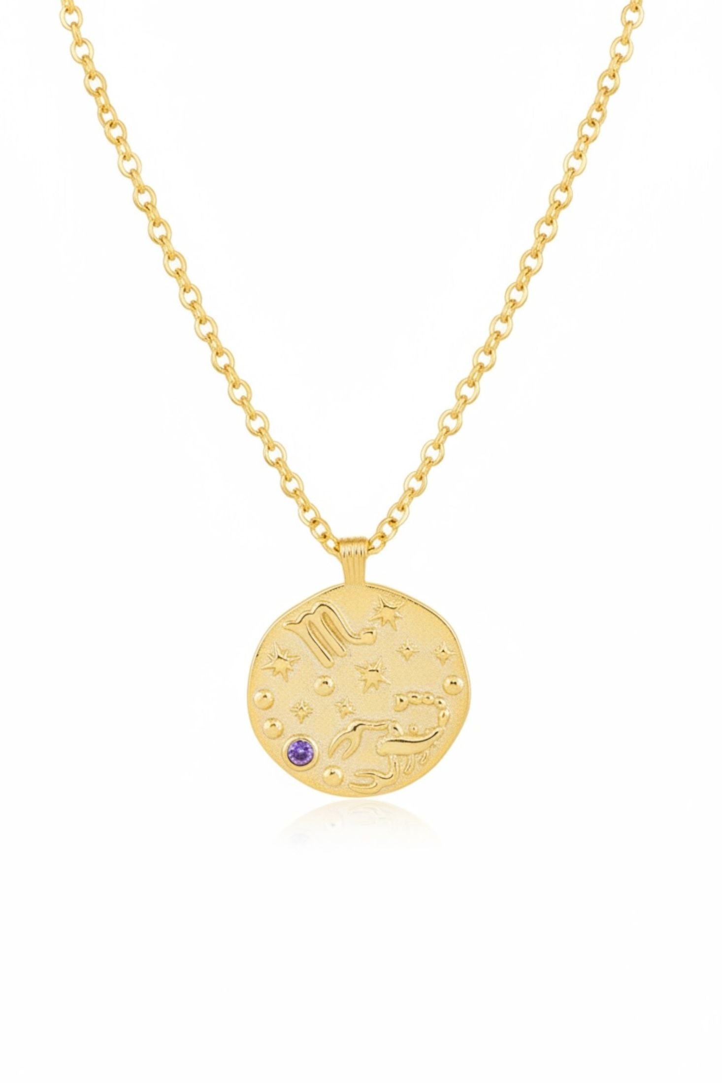 Gold necklace with a round pendant featuring celestial designs on a white background