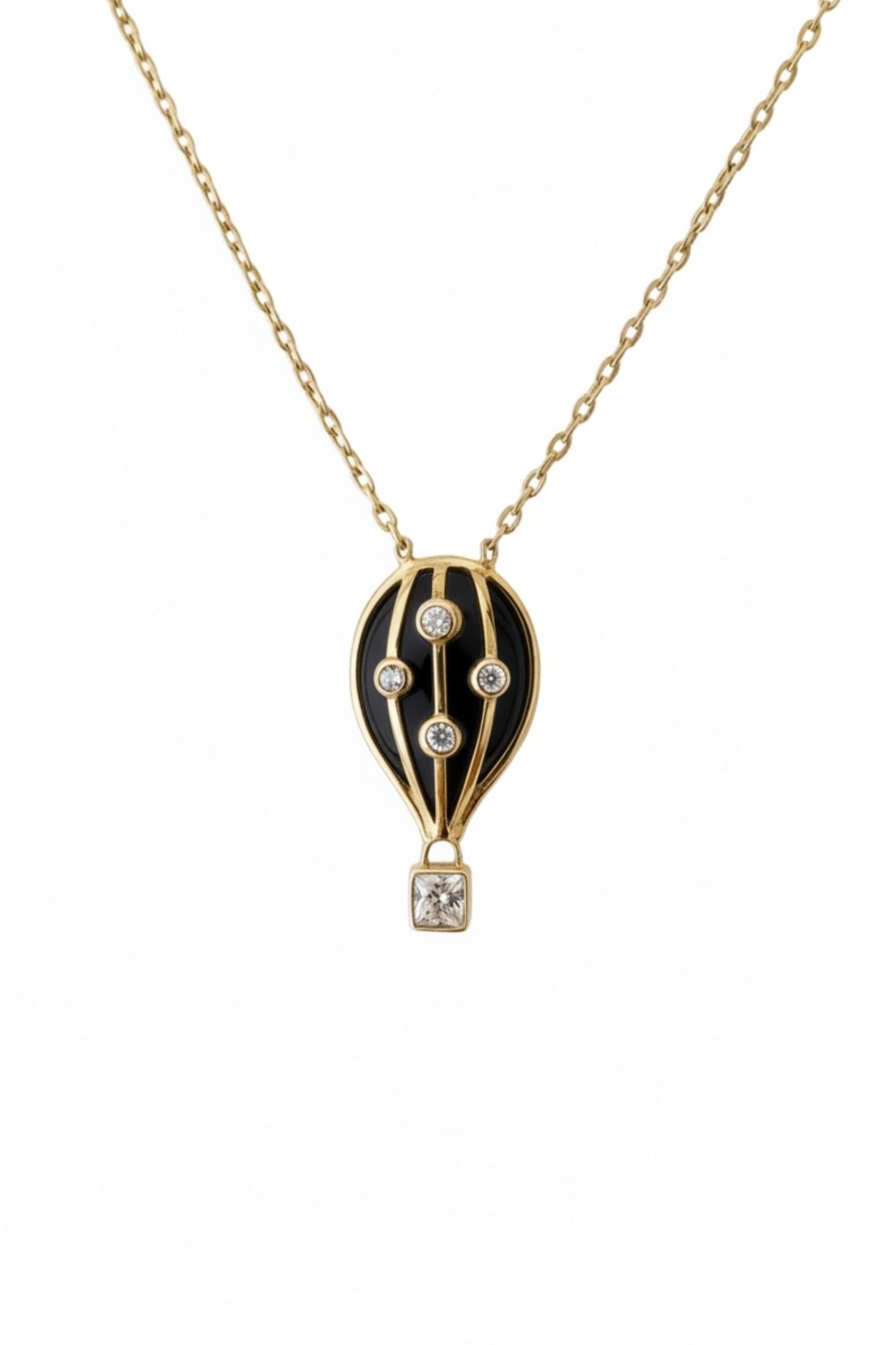 Gold necklace with a black hot air balloon pendant on a white background
