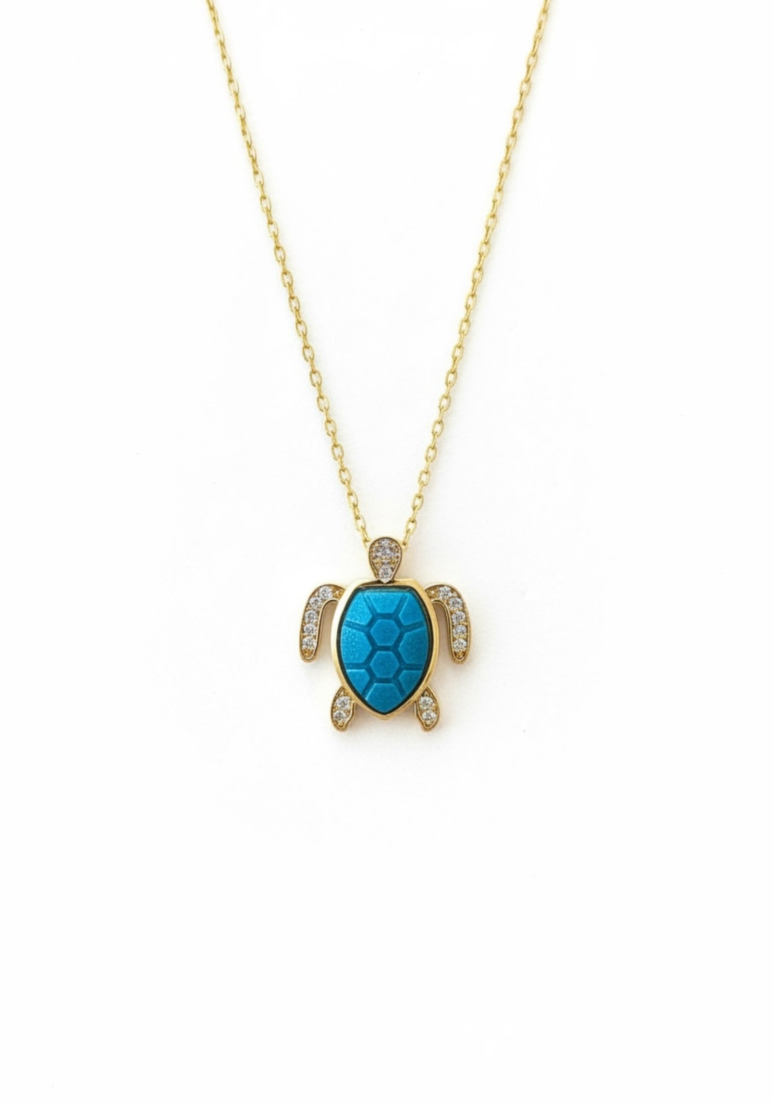 Turquoise turtle pendant necklace on a gold chain against a white background