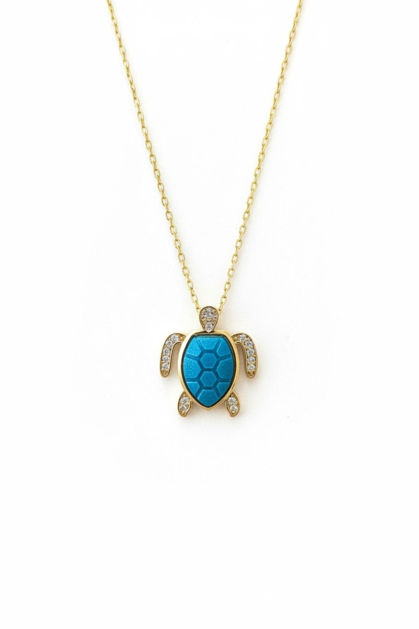 Turquoise turtle pendant necklace on a gold chain against a white background