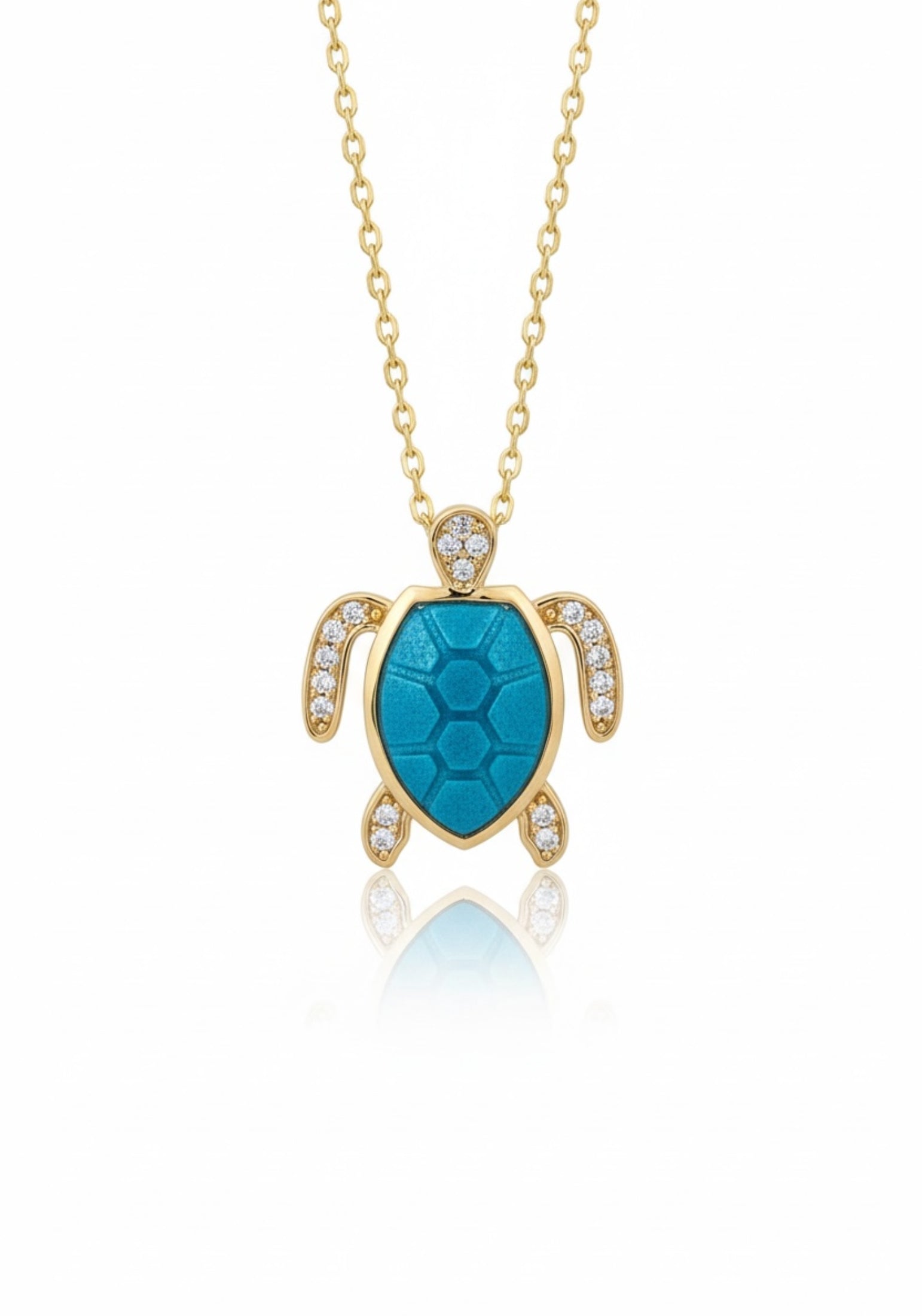 Gold turtle pendant with turquoise center and clear stones on a gold chain against a white background