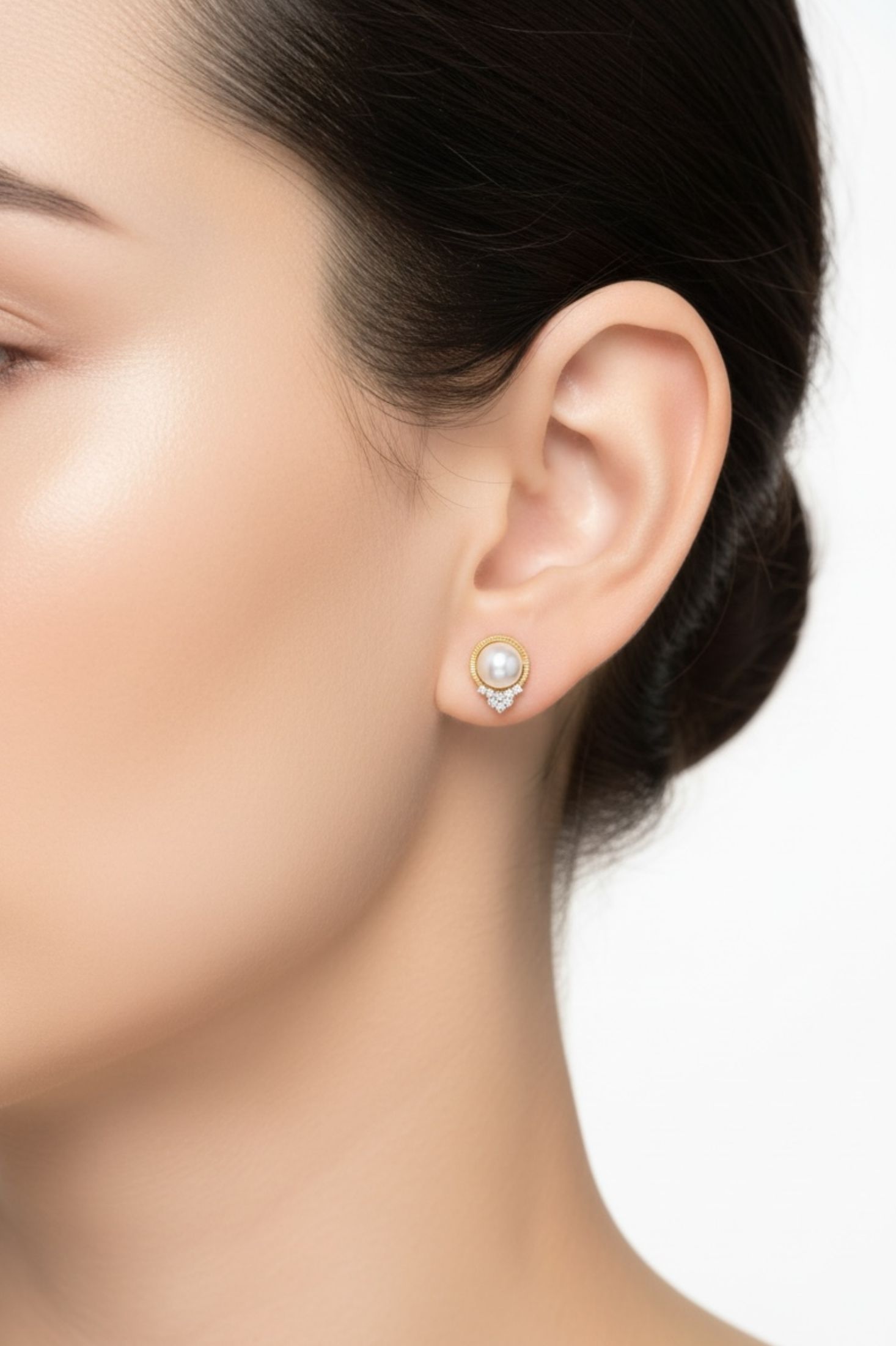 Close-up of a woman wearing a pearl earring on a white background