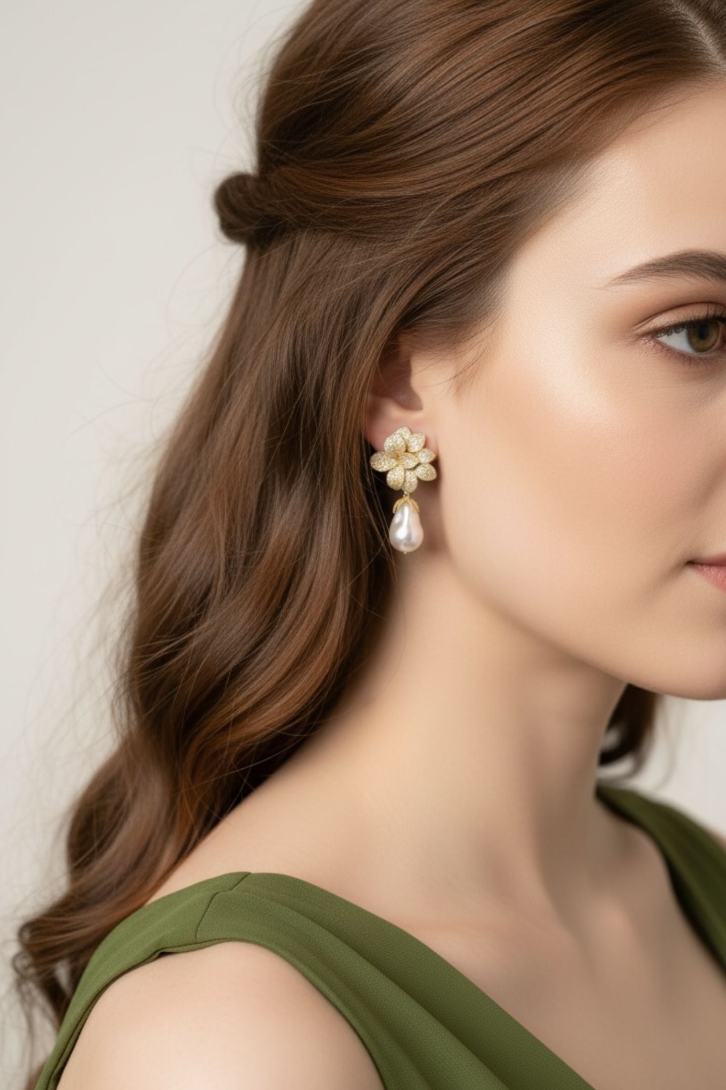 Close-up of a woman wearing floral earrings with a neutral background