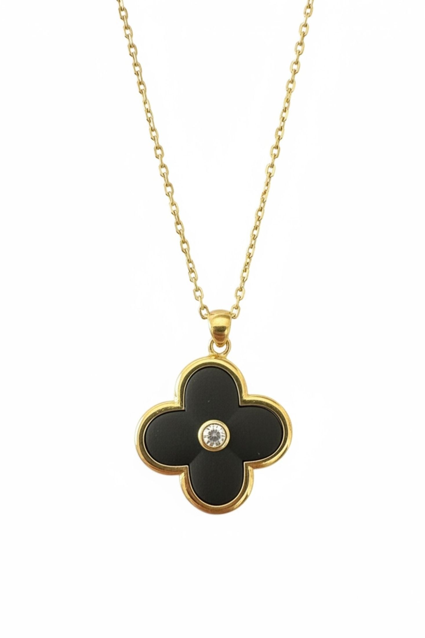 Black clover-shaped pendant with a gold chain on a white background