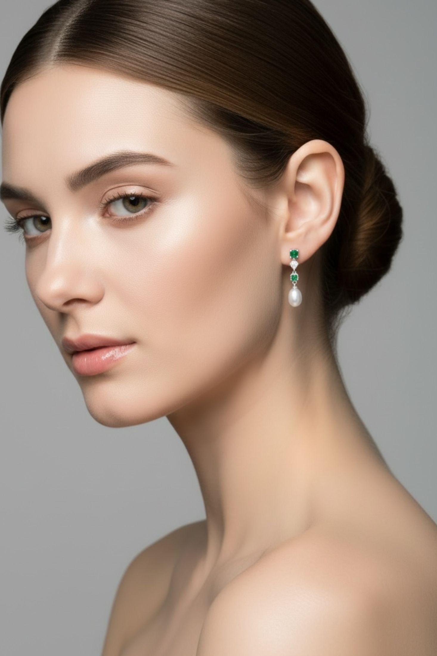 Angled view of Pearl Whisper Drop Earrings Emerald Silver, showing pearl and emerald detailing, silver finish and the jewellery profile.