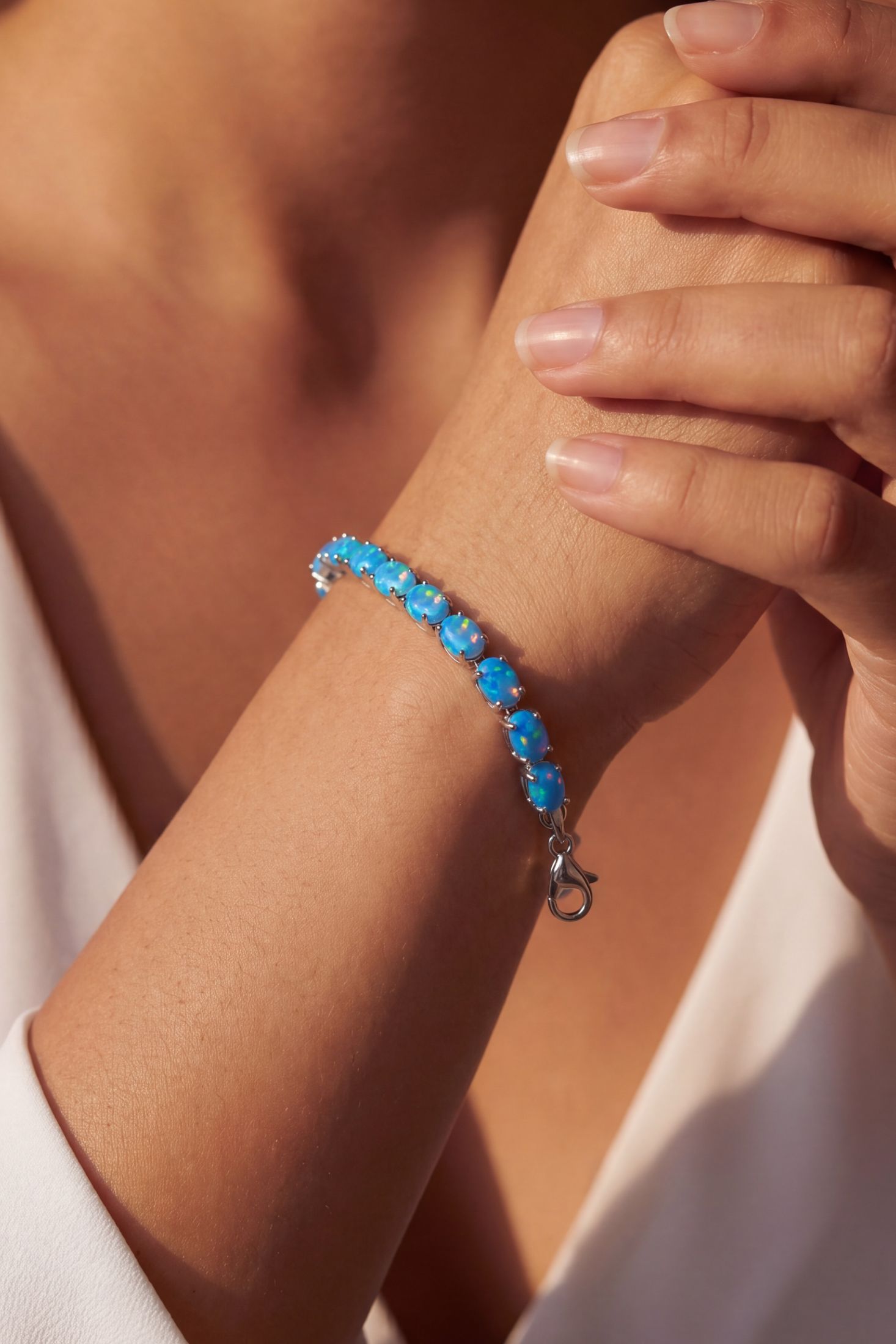 Angled view of Blue Opal Tennis Bracelet Silver, showing silver finish and the jewellery profile.
