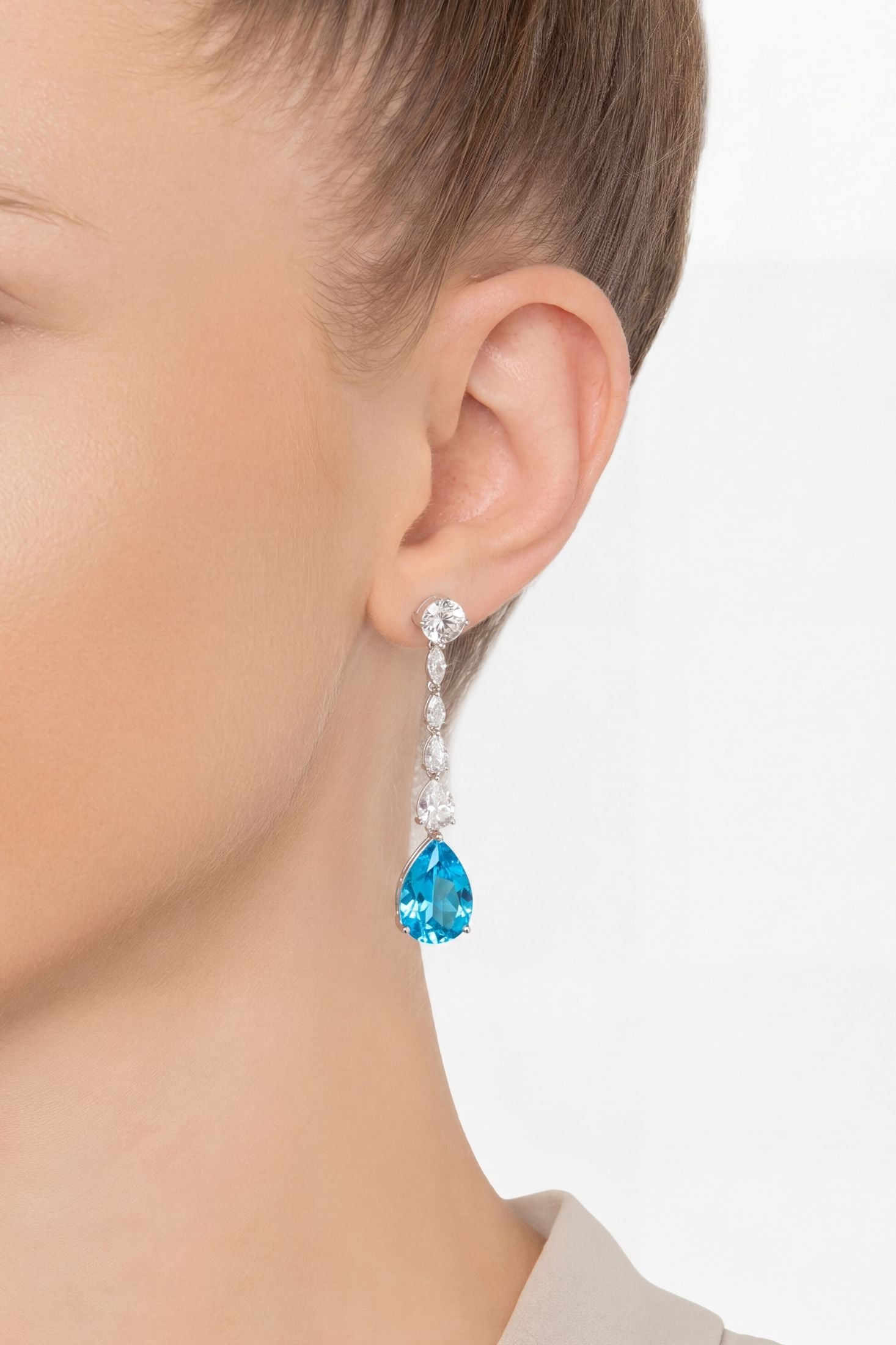 Angled view of Bardot Blue Topaz Drop Earrings Silver, showing blue topaz detailing, silver finish and the jewellery profile.