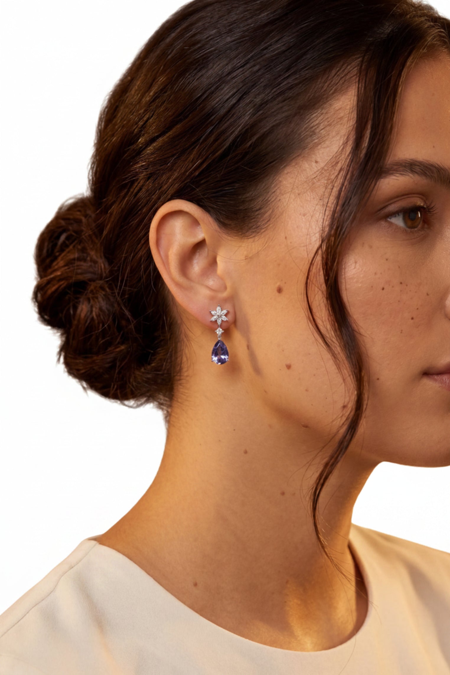 Angled view of Sunflower Tanzanite Drop Earrings Silver, showing flower design, tanzanite detailing, silver finish and the jewellery profile.