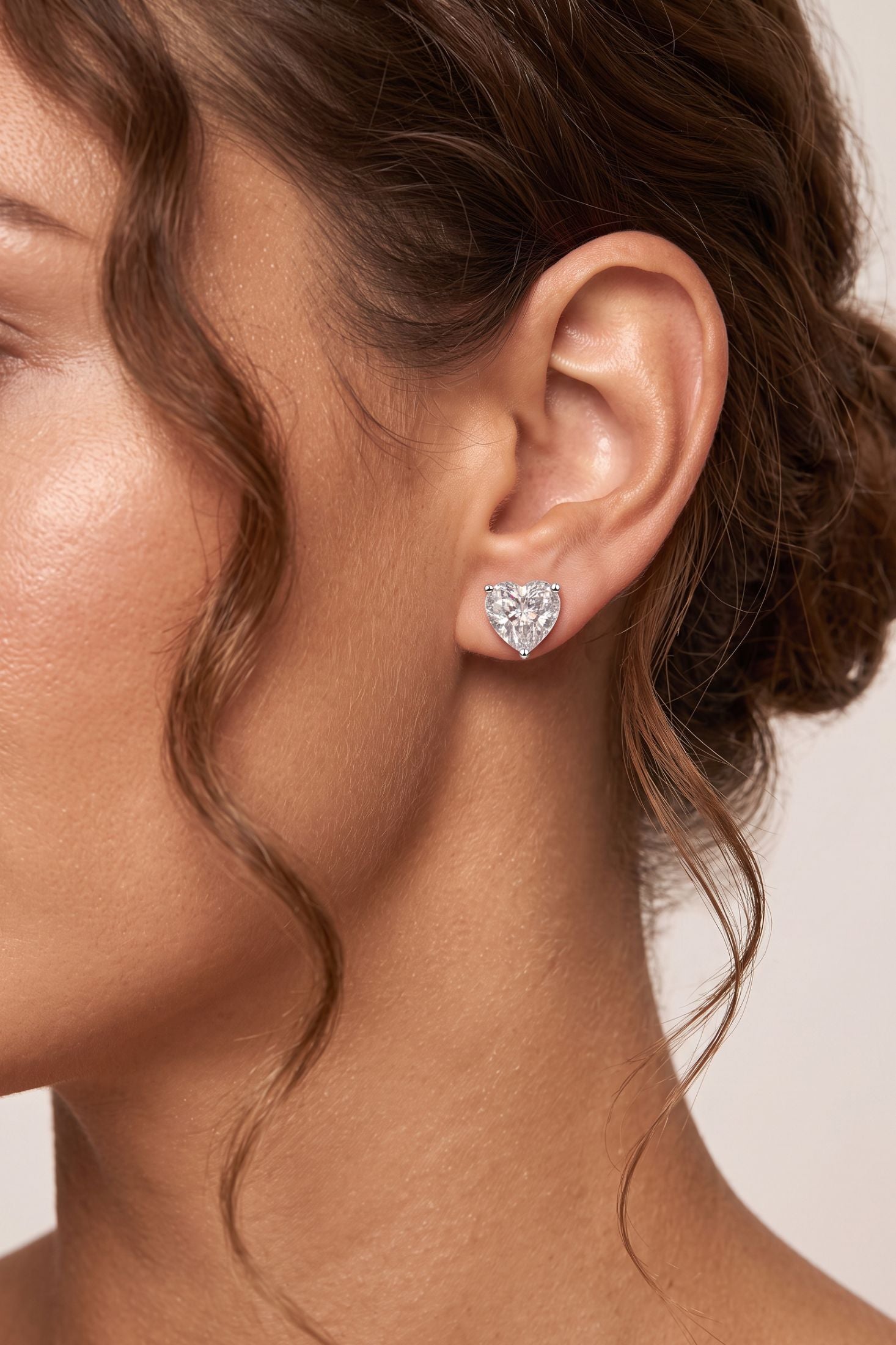 Angled view of Amore Heart Moissanite Stud Earrings Silver, showing heart design, silver finish and the jewellery profile.