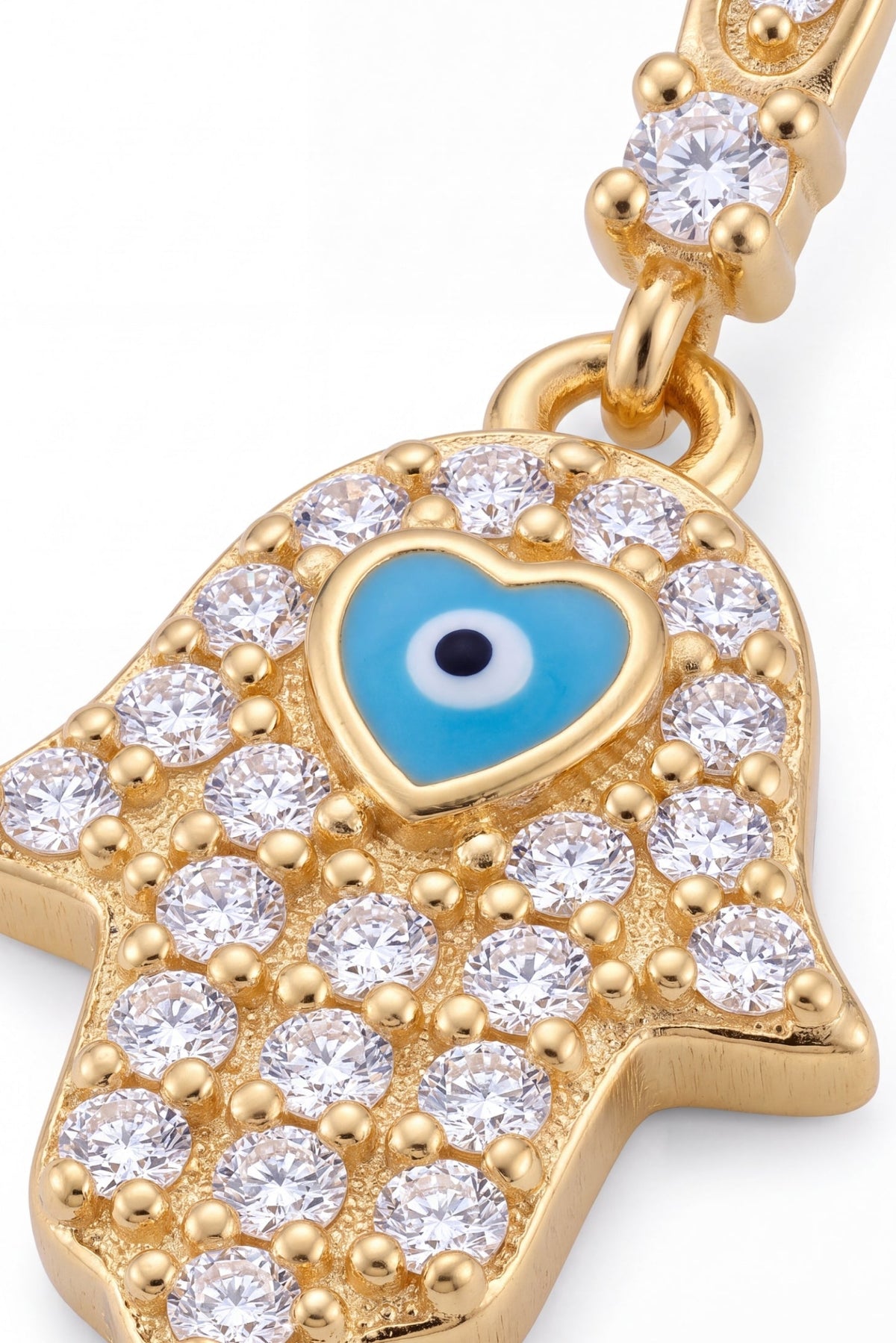 Gold hamsa hand pendant charm with clear cubic zirconia stones and a central blue enamel evil eye heart, shown on a white background.
