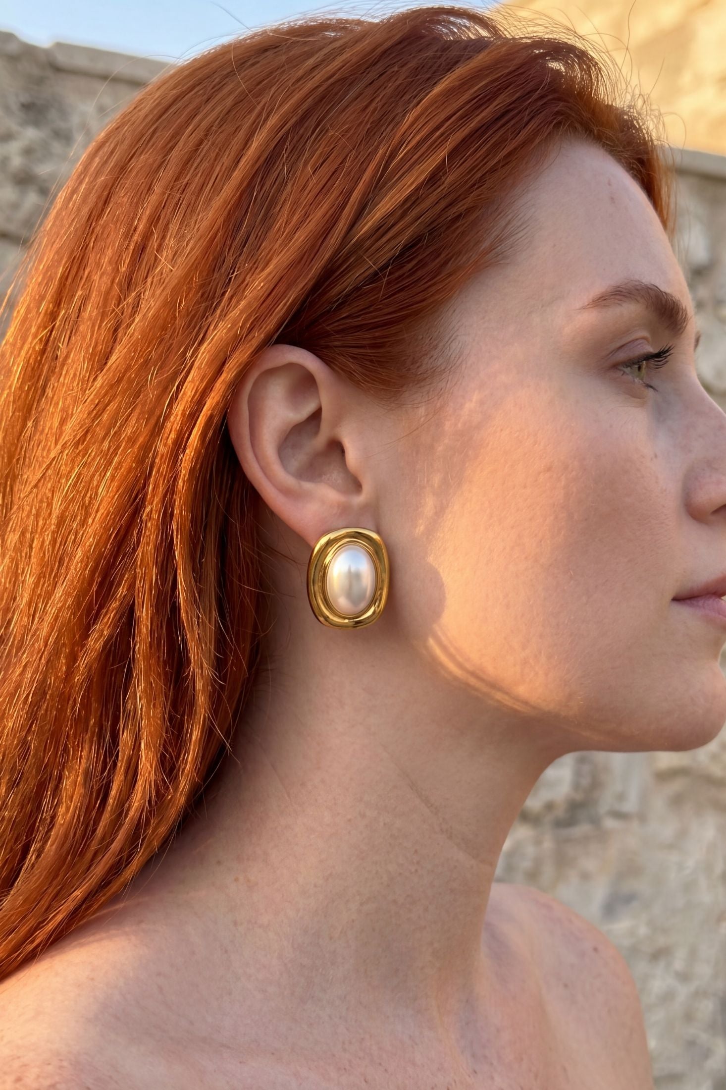 Angled view of Carrington Oval Pearl Knot Earrings Gold, showing pearl detailing, gold finish and the jewellery profile.