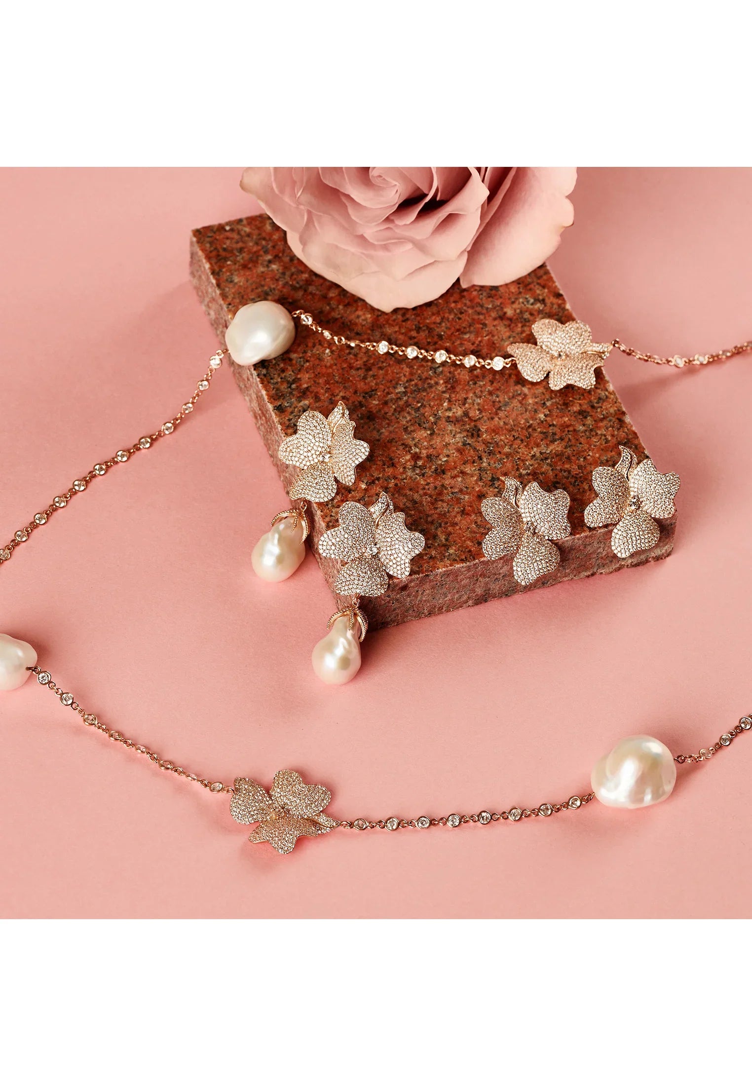Large rose gold flower earrings with and without pearls, alongside a matching necklace with pearls.
