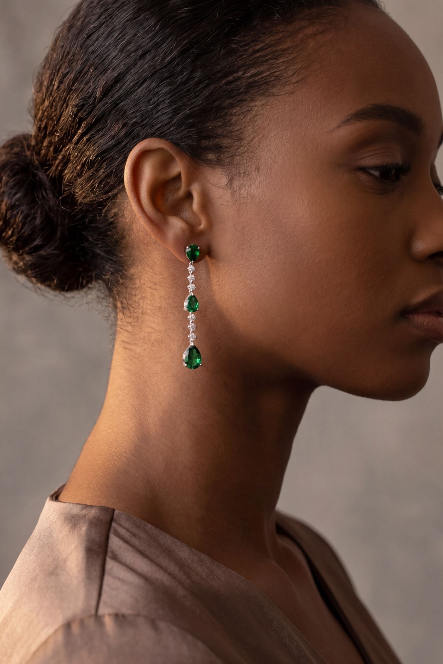 Angled view of Elizabeth Drop Earrings Emerald Silver, showing emerald detailing, silver finish and the jewellery profile.