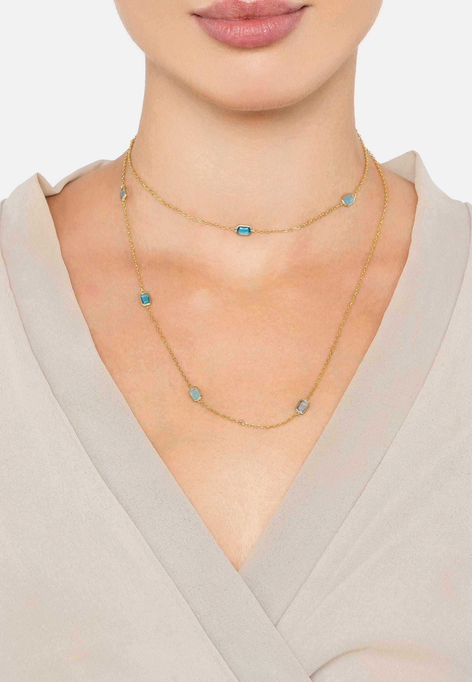The necklace worn layered by a model.