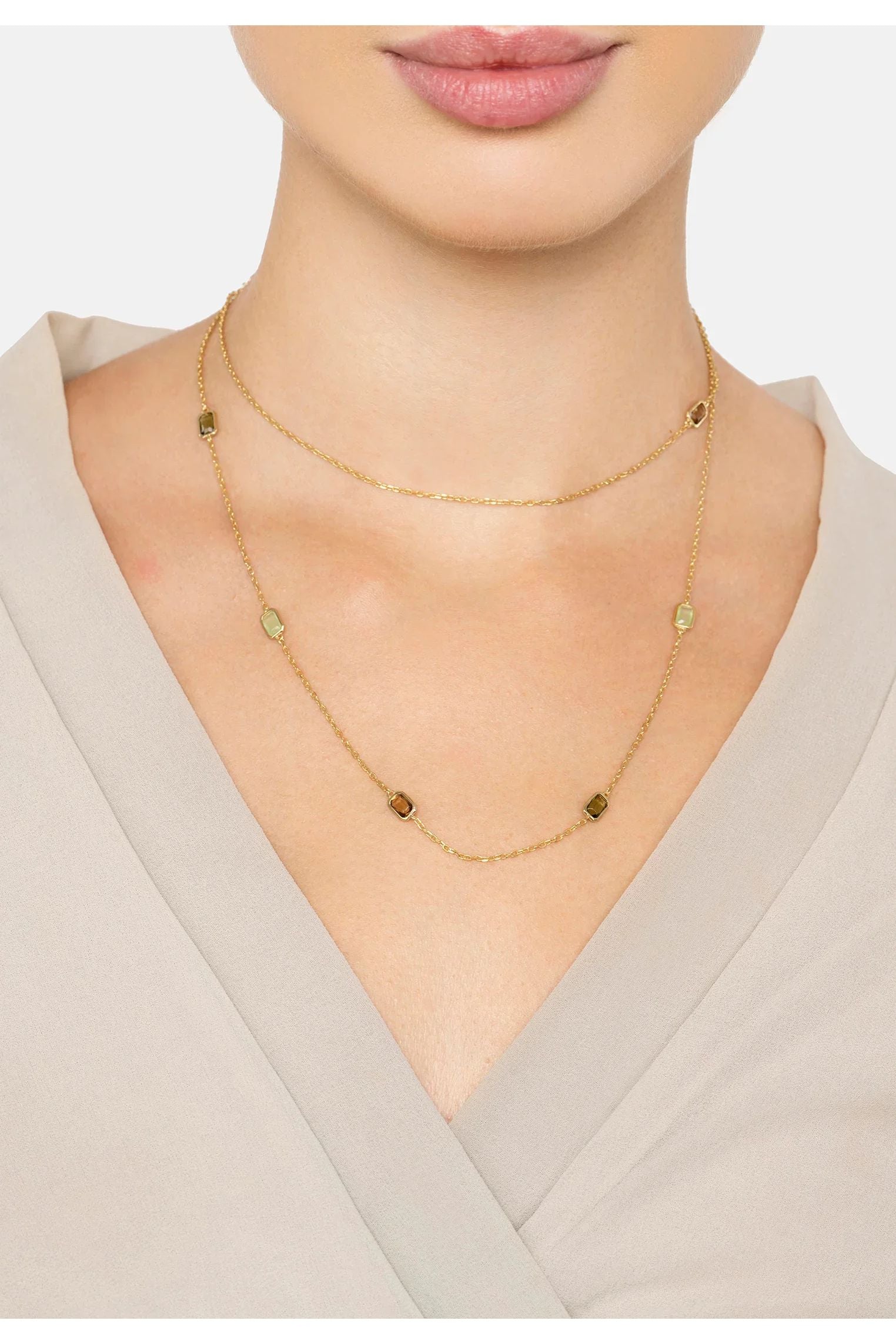 The necklace worn layered by a model.