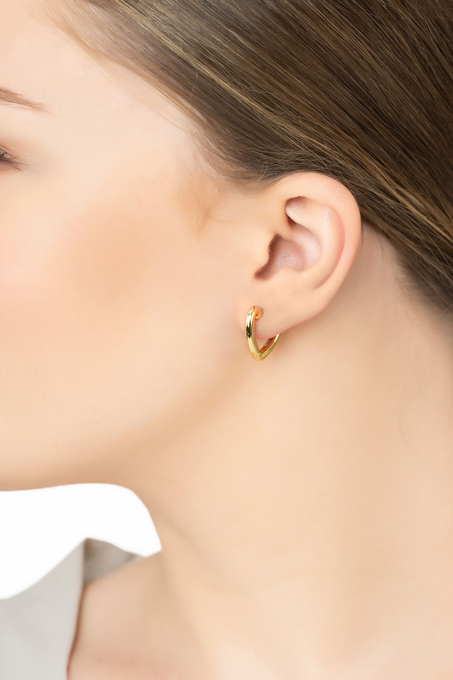 Angled view of My Love Heart Hoop Earrings Gold, showing heart design, gold finish and the jewellery profile.
