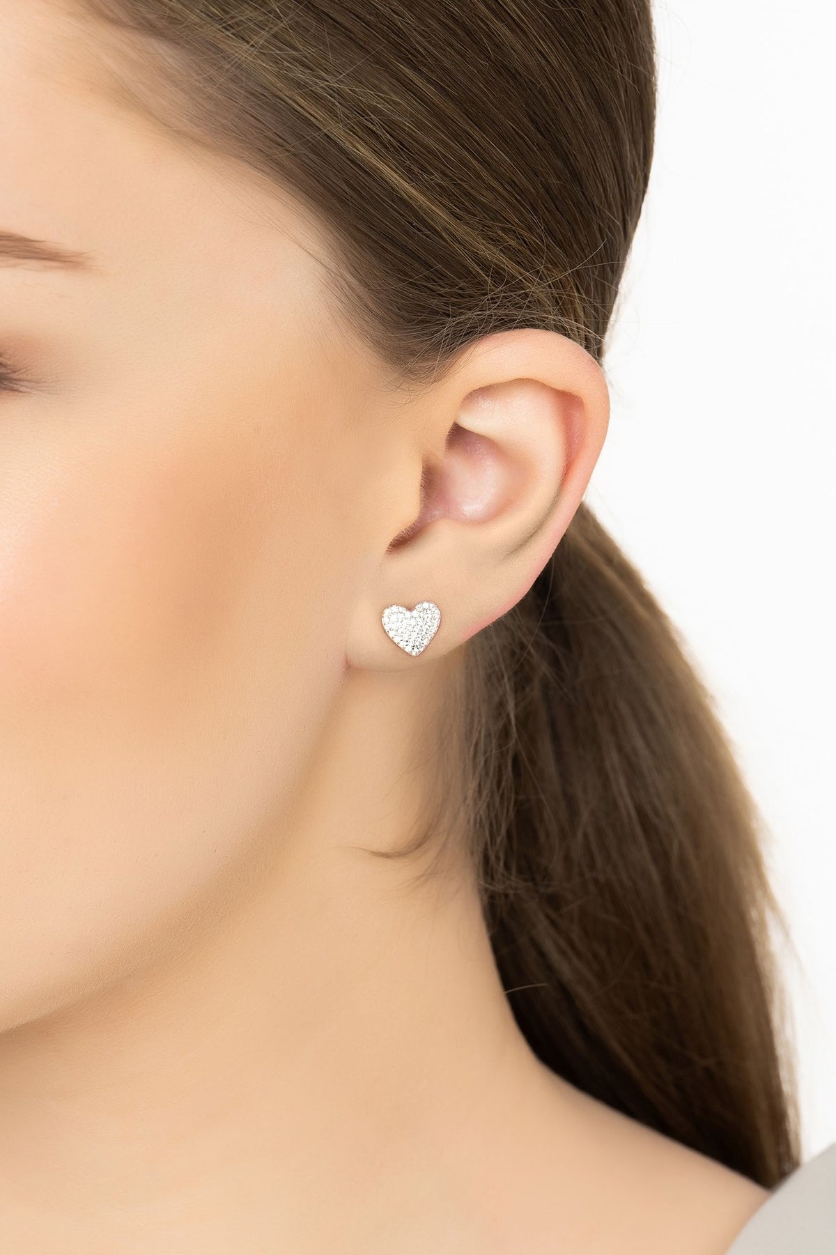 Angled view of Sweetheart Sparkle Stud Earrings Silver, showing heart design, silver finish and the jewellery profile.