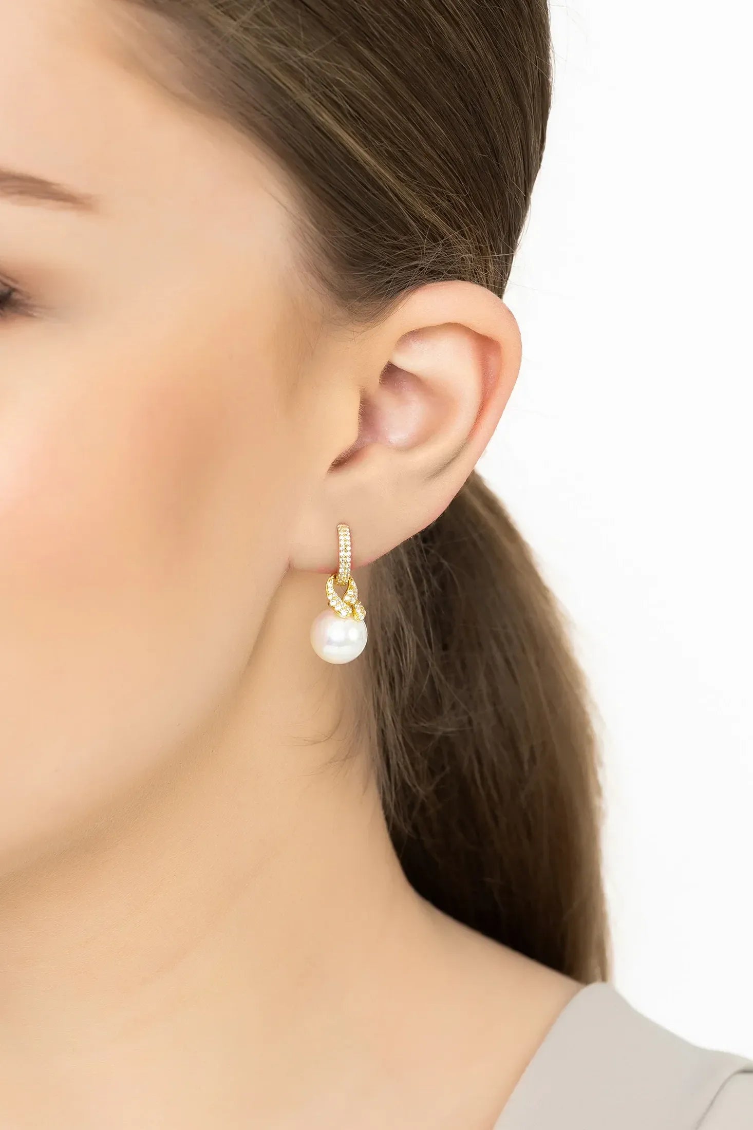 Angled view of Tie The Knot Drop Pearl Earrings Gold, showing pearl detailing, gold finish and the jewellery profile.