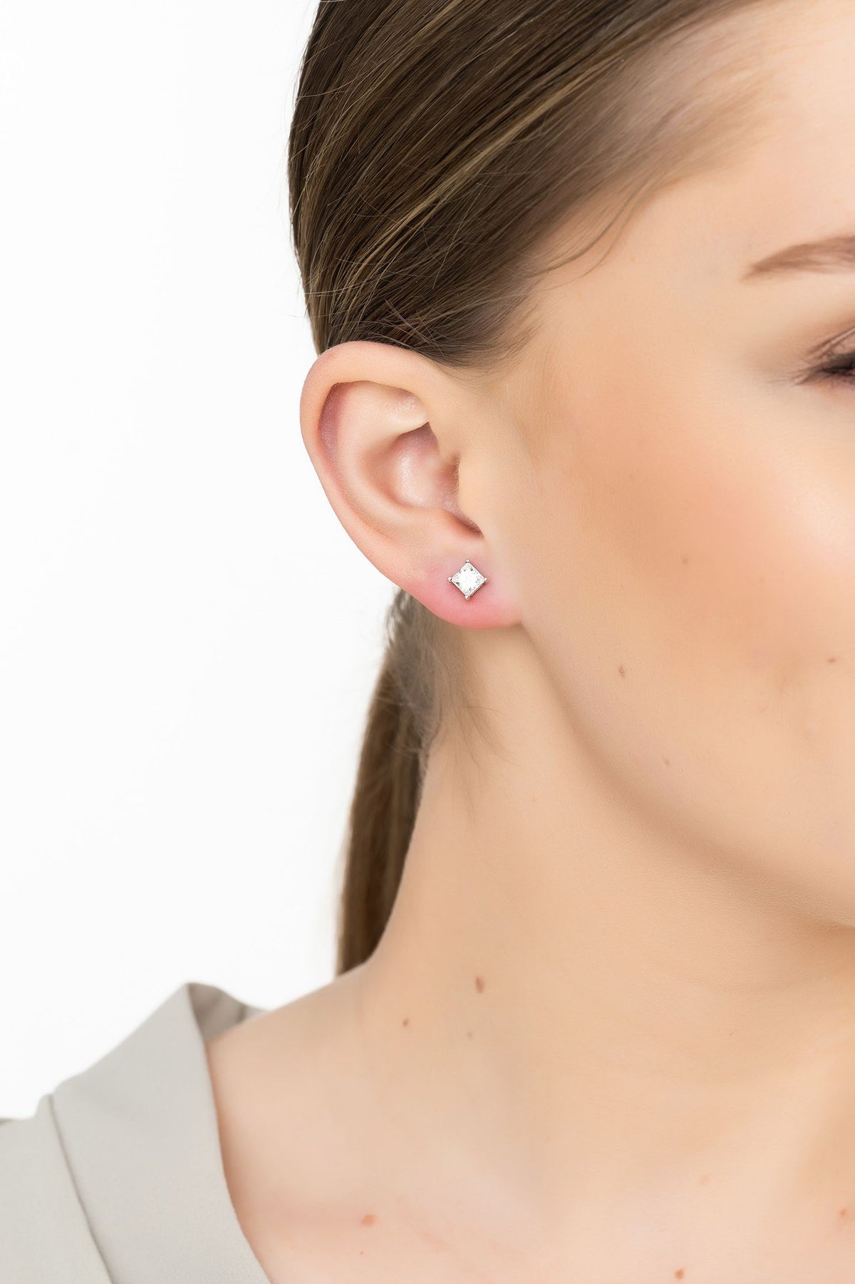 Angled view of Square Solitaire Stud Earrings Moissanite Silver, showing silver finish and the jewellery profile.