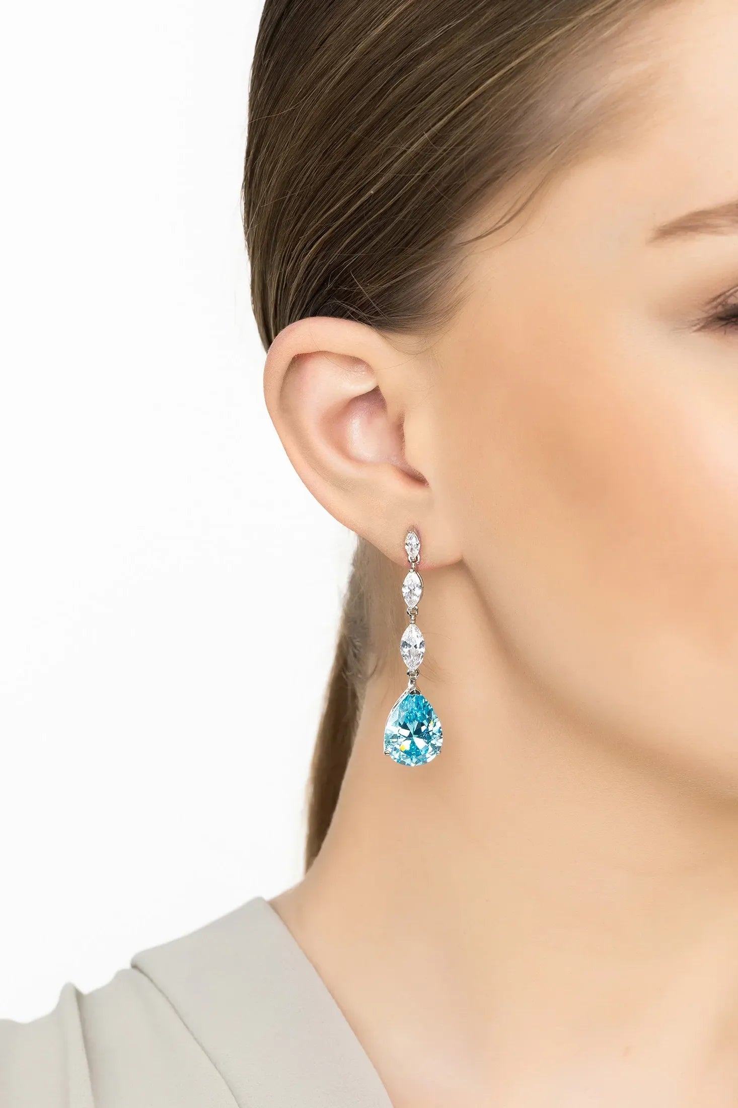 Angled view of Zara Teardrop Blue Topaz Gemstone Earrings Silver, showing blue topaz detailing, silver finish and the jewellery profile.