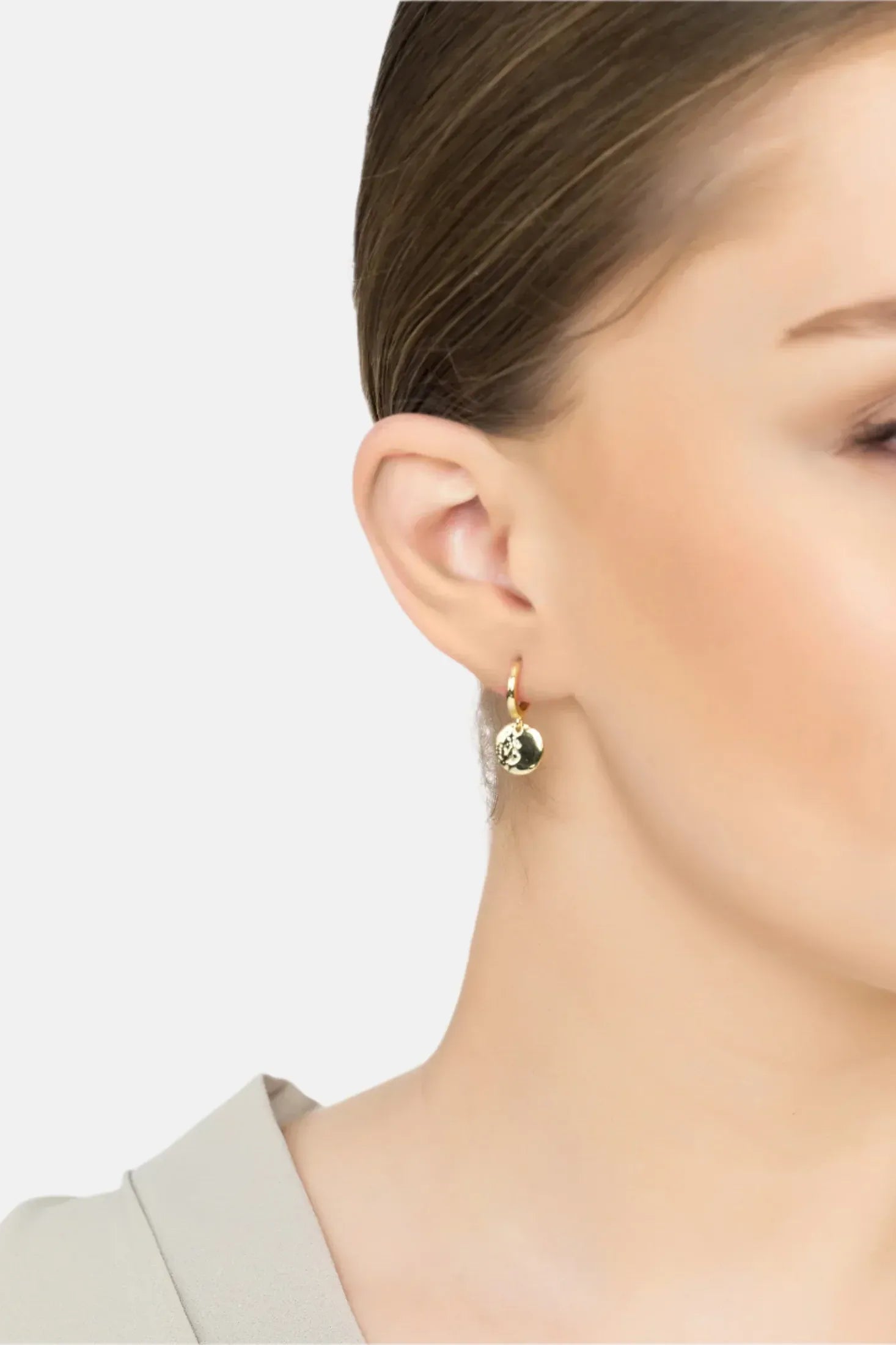 Angled view of Lunar Moon Huggie Hoop Earrings Gold, showing moon design, gold finish and the jewellery profile.
