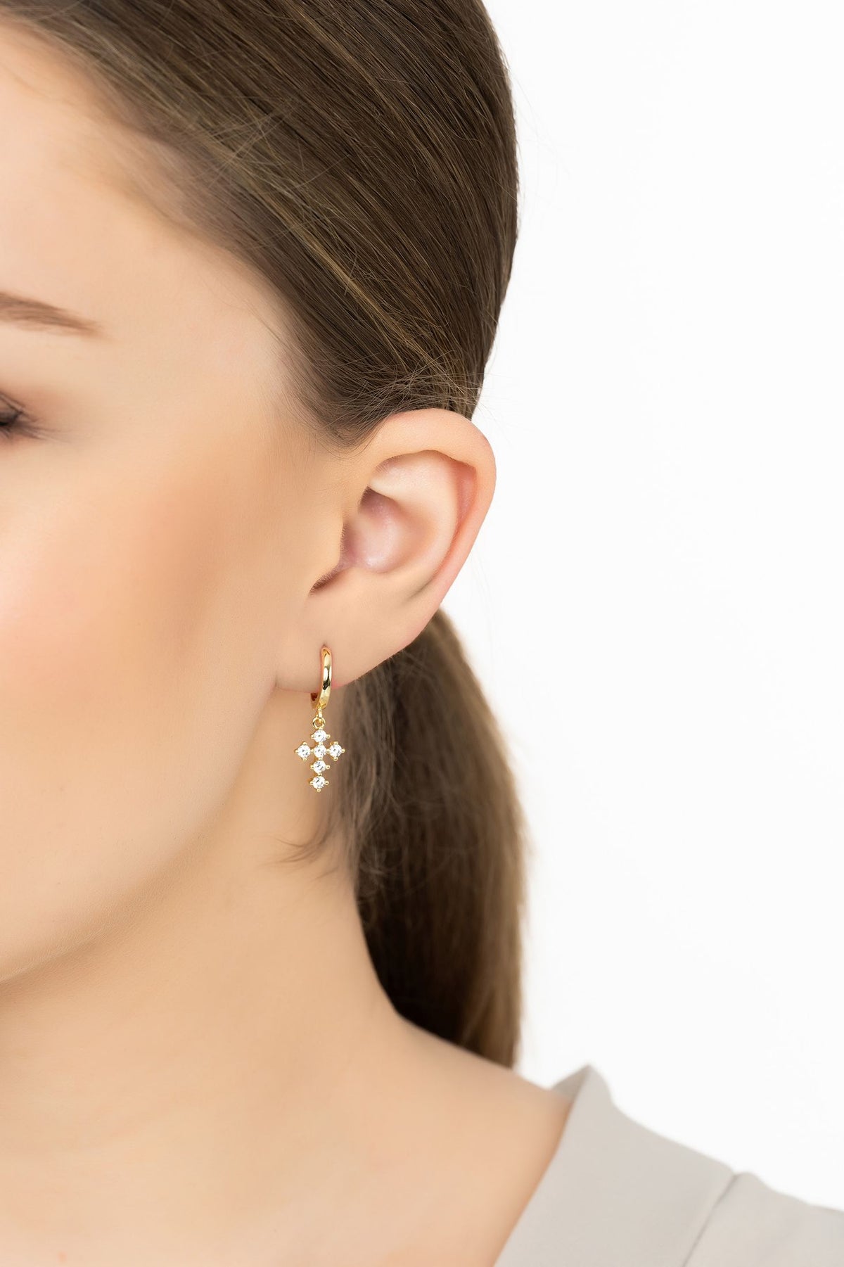 Angled view of Divina Fashion Huggie Hoop Earrings Gold, showing gold finish and the jewellery profile.
