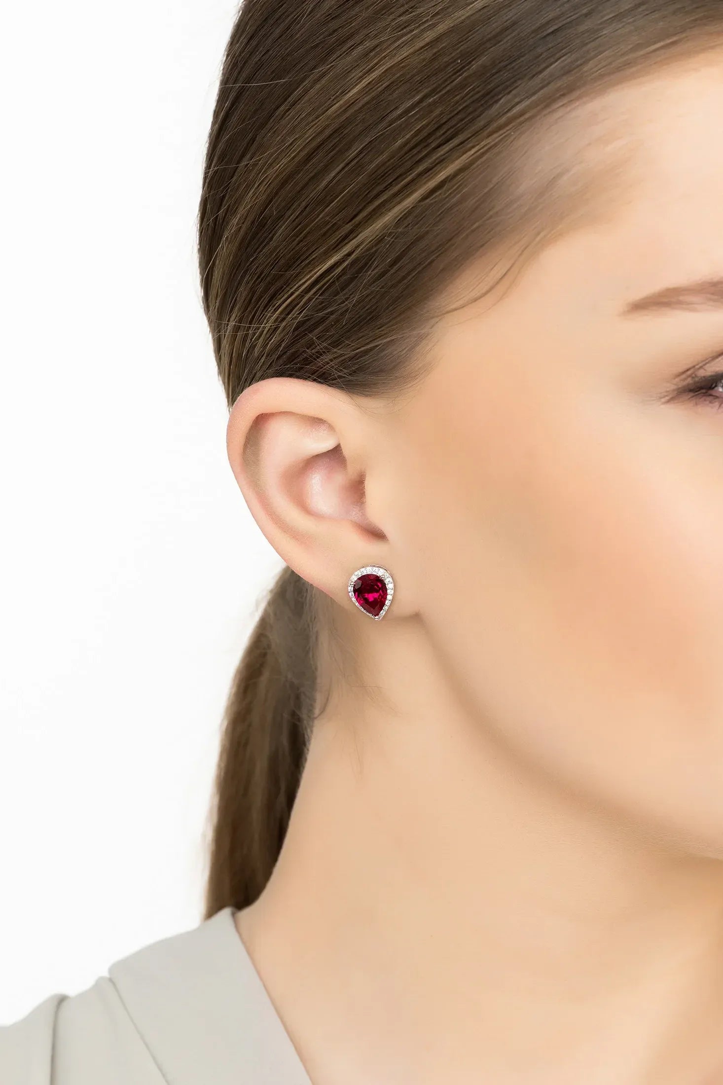 Angled view of Theodora Ruby Teardrop Gemstone Stud Earrings Silver, showing ruby detailing, silver finish and the jewellery profile.