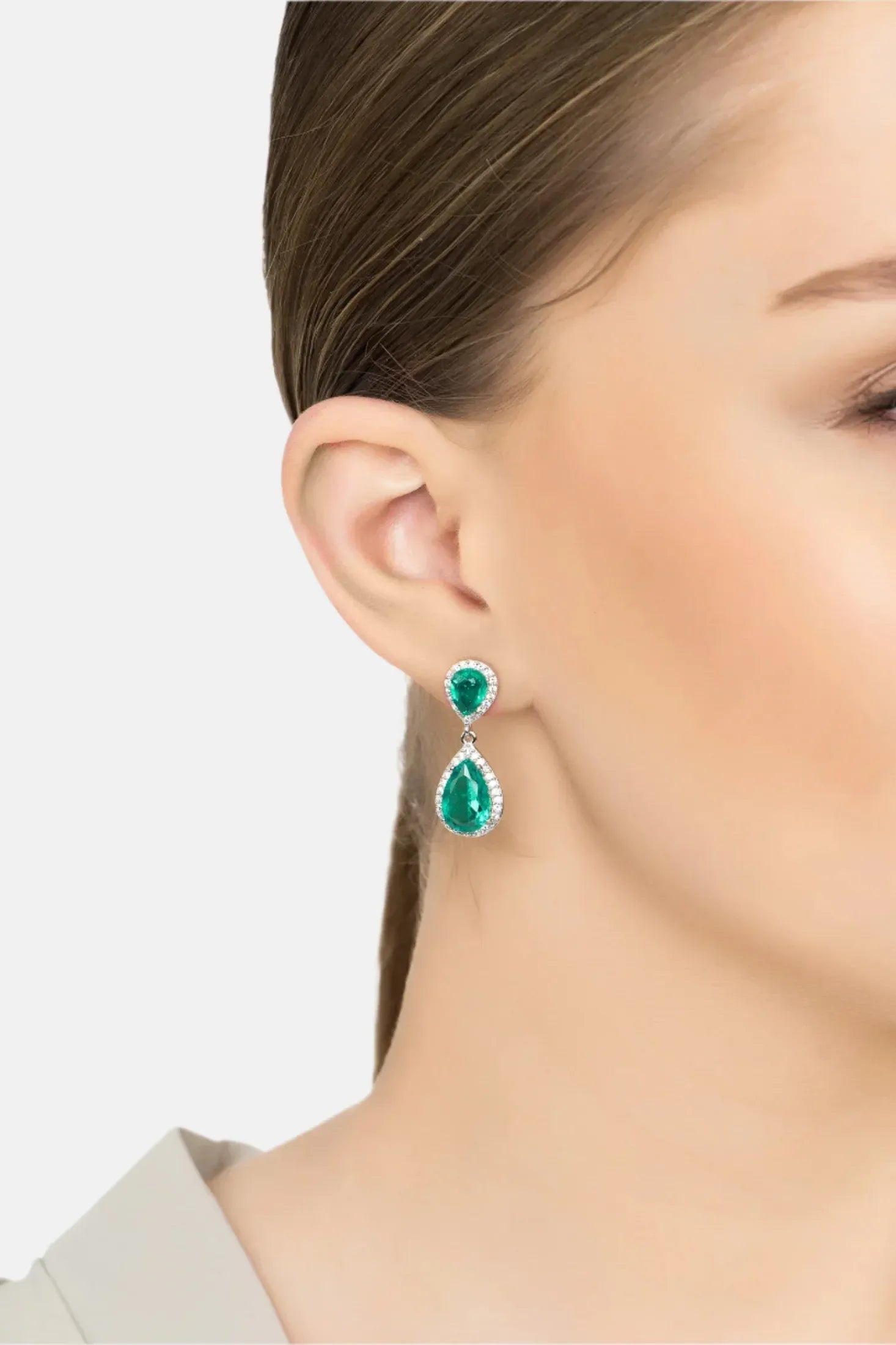 Angled view of Odette Teardrop Colombian Emerald Earrings Silver, showing emerald detailing, silver finish and the jewellery profile.