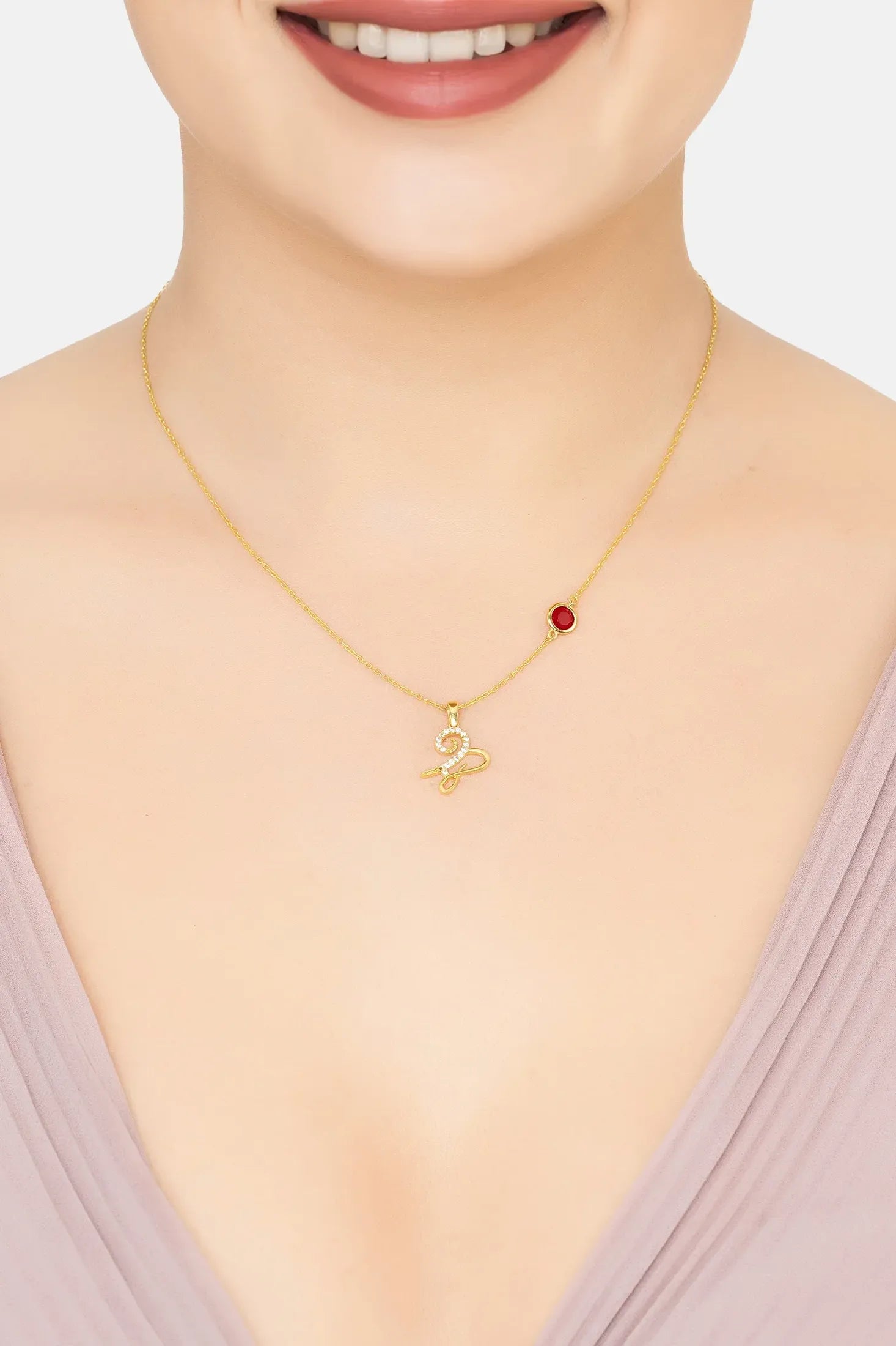 Capricorn sign and birthstone gold necklace worn by a model.