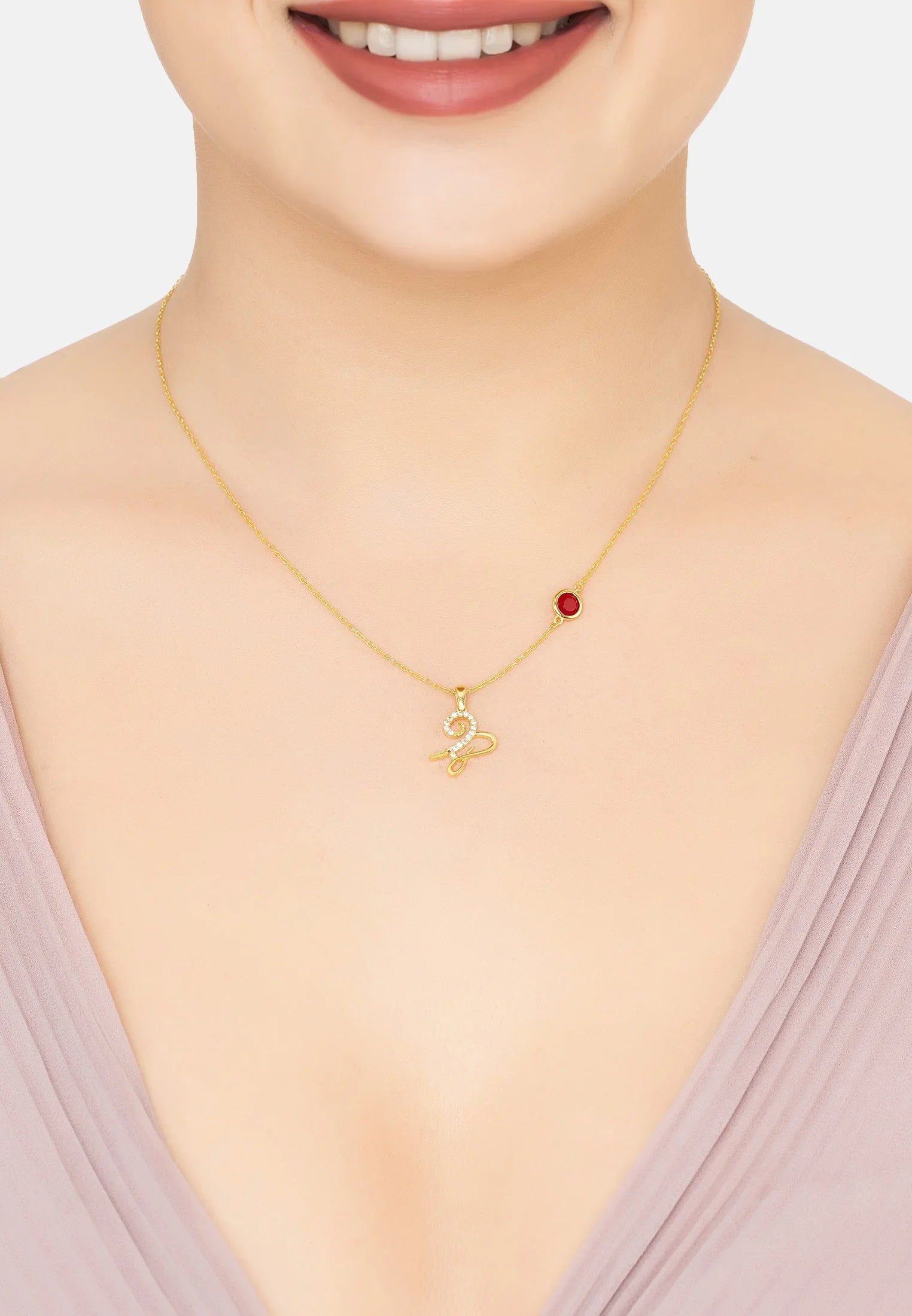 Capricorn sign and birthstone gold necklace worn by a model.
