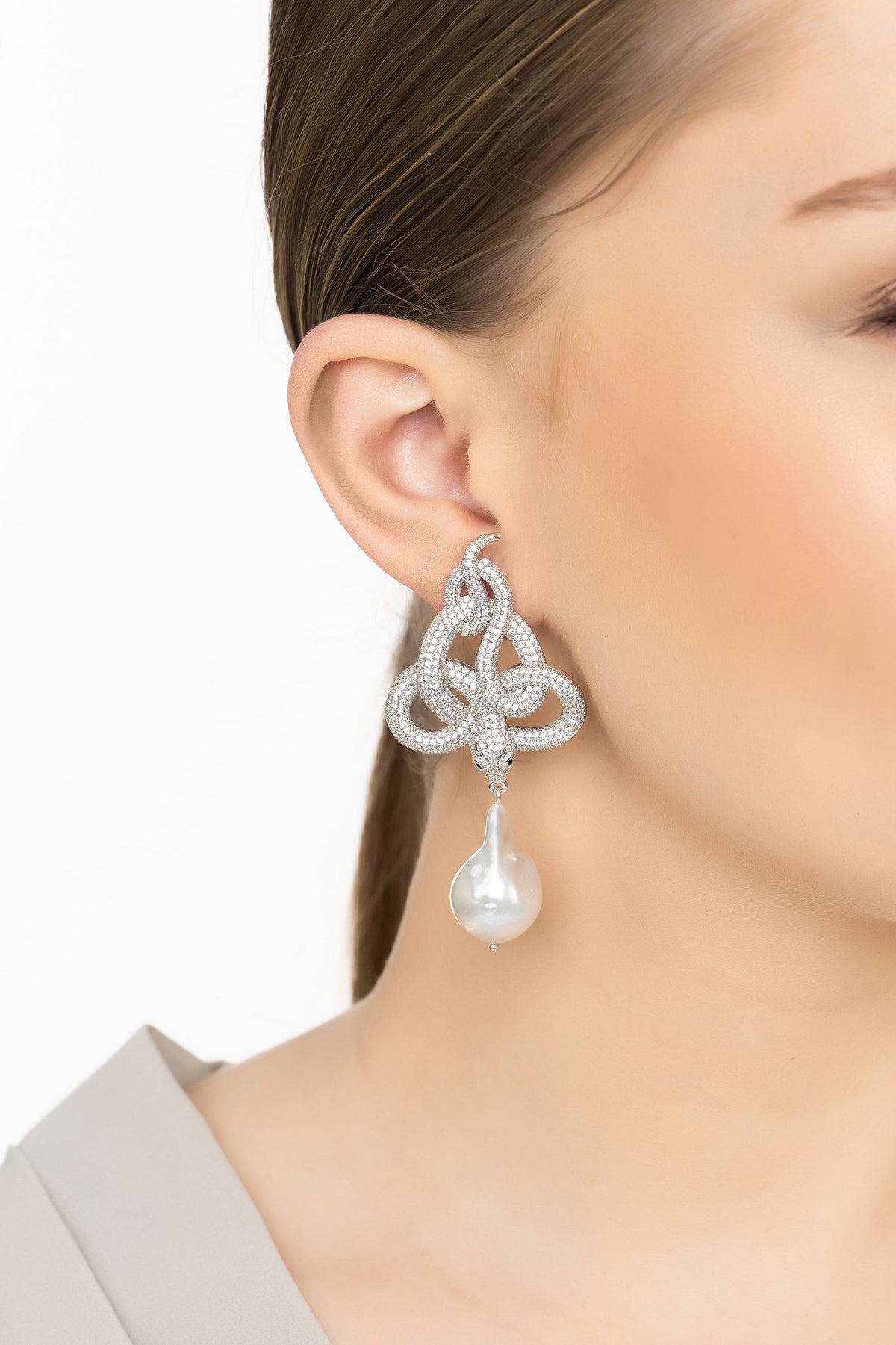Angled view of Viper Snake Baroque Pearl Drop Earrings Silver White CZ, showing snake design, baroque pearl and pearl detailing, silver finish and the jewellery profile.