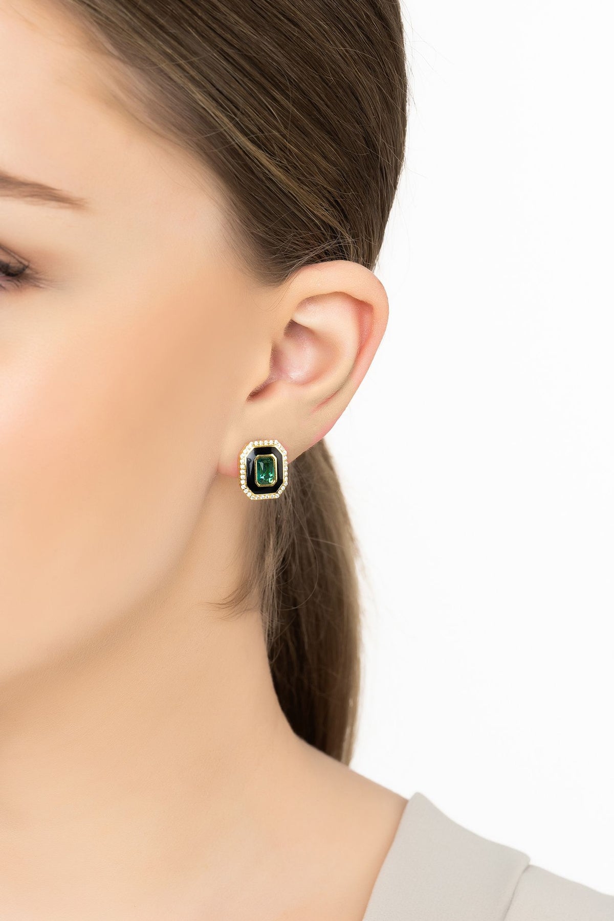 Angled view of Art Deco Emerald And Enamel Stud Earrings Gold, showing emerald detailing, gold finish and the jewellery profile.